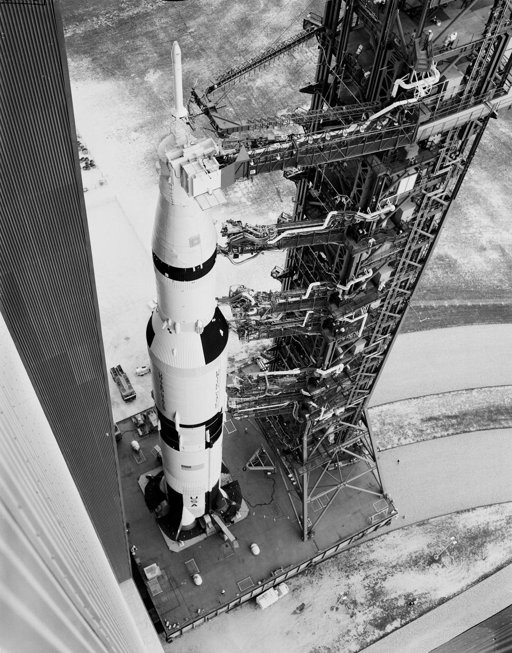 A bird's-eye view of Apollo 6 and its gantry leaving the Vehicle Assembly Building on the transporter heading to the launch site on Pad 39-A at Kennedy Space Center. The towering 363-foot Saturn V was a multi-stage, multi-engine launch vehicle standing taller than the Statue of Liberty. Altogether, the Saturn V engines produced as much power as 85 Hoover Dams.