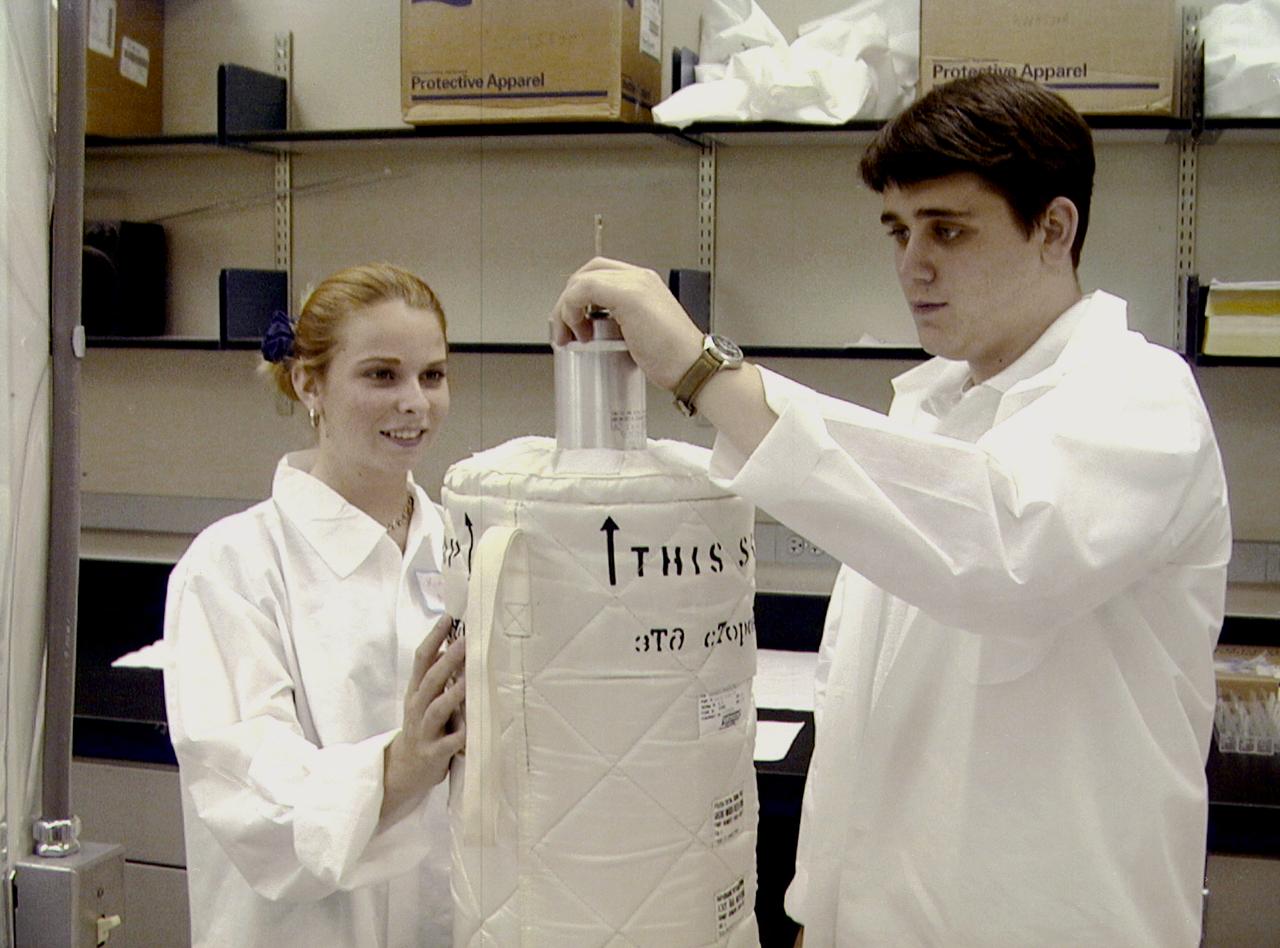 Kim Nelson, left, of Sandalwood High School in Jacksonville, FL, helps Steven Nepowada, right, of Terry Parker High School in Jacksonville, practice loading a protein sample into a thermos-like container, known as Dewar. Students from Jacksonville worked with researchers from NASA/Marshall Space Flight Center (MSFC), as well as universities, in Huntsville, AL, on an experiment for the International Space Station (ISS). The proteins are placed in plastic tubing that is heat-sealed at the ends, then flash-frozen and preserved in a liquid nitrogen Dewar. Aboard the ISS, the nitrogen will be allowed to evaporated so the samples thaw and then slowly crystallize. They will be analyzed after return to Earth. Photo credit: NASA/Marshall Space Flight Center (MSFC)