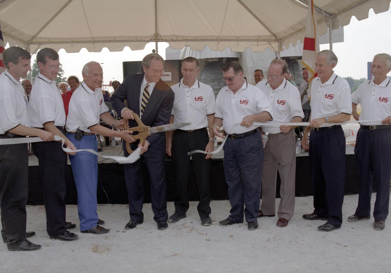 Alabama Governor Don Seigleman cuts the ribbon marking the dedication of the Saturn V rocket replica that was constructed at the U. S. Space and Rocket Center in honor of the 30th arniversary of the lunar landing. Accompanying the Governor are (L/R): Mike Wing, CEO US Space Rocket Center; Mike Gillespie, Madison County Commissioner, Dist. Seven; Buzz Aldrin, Apollo 11 Astronaut; Governor Seigleman; Walt Cunningham, Apollo 7 Astronaut; Dick Gordon, Apollo 12 Astronaut; Ed Mitchell, Apollo 14 Astronaut; Charlie Duke, Apollo 16 Astronaut; and Owen Garriott, Skylab 3 Astronaut.