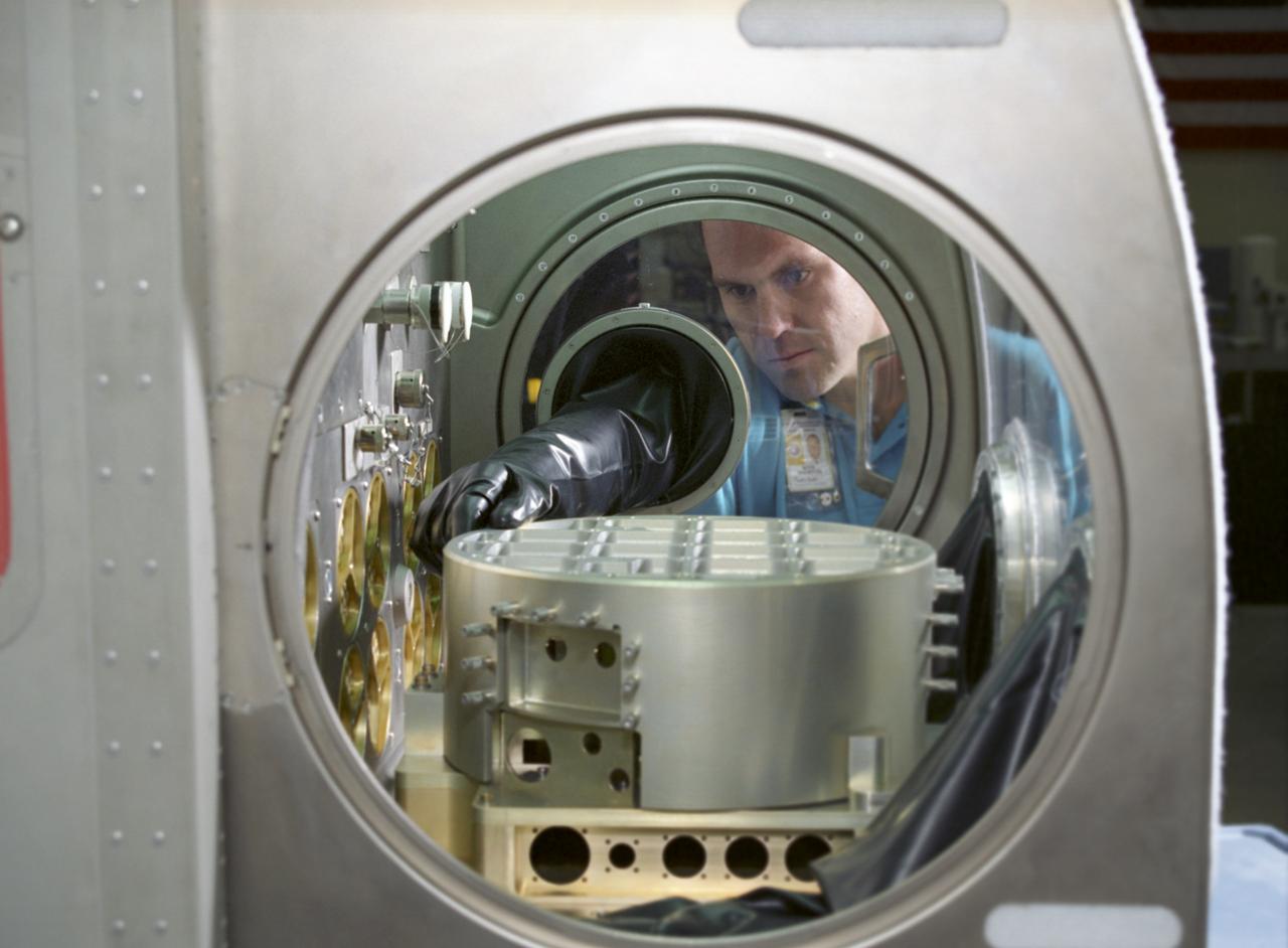 This excellent shot of Marshall Space Flight Center's (MSFC's) Mark Whorton, testing experiment hardware in the Microgravity Science Glovebox Ground Unit delivered to MSFC on August 30, 2002, reveals a close look at the components inside of the Glovebox. The unit is being used at Marshall's Microgravity Development Laboratory to test experiment hardware before it is installed in the flight Glovebox aboard the International Space Station (ISS) U.S. Laboratory Module, Destiny. The glovebox is a sealed container with built in gloves on its sides and fronts that enables astronauts to work safely with experiments that involve fluids, flames, particles, and fumes that need to be safely contained.