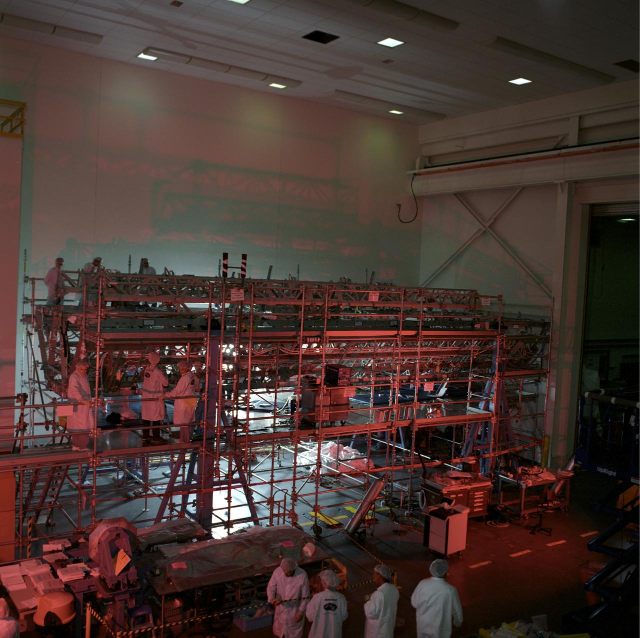 This image shows the Integrated Truss Assembly S-1 (S-One), the Starboard Side Thermal Radiator Truss, for the International Space Station (ISS) undergoing final construction in the Space Station manufacturing facility at the Marshall Space Flight Center. The S1 truss provides structural support for the orbiting research facility's radiator panels, which use ammonia to cool the Station's complex power system. Delivered and installed by the STS-112 mission, the S1 truss, attached to the S0 (S Zero) truss installed by the previous STS-110 mission, flows 637 pounds of anhydrous ammonia through three heat rejection radiators. The truss is 45-feet long, 15-feet wide, 10-feet tall, and weighs approximately 32,000 pounds. Manufactured by the Boeing Company in Huntington Beach, California, the truss primary structure was transferred to the Marshall Space Flight Center in February 1999 for hardware installations and manufacturing acceptance testing.