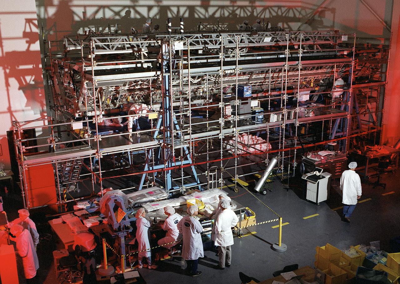 Boeing Company technicians assemble the S-1 truss (starboard side truss) for the International Space Station at the Marshall Space Flight Center.