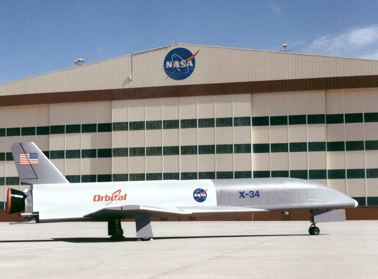 The X-34 demonstrator is shown being taken out of its hangar and placed on the tarmac. The X-34 was classified as part of the Pathfinder class demonstrators which include small experimental vehicles or less expensive flight experiments. These demonstrators were driven by technology and were executed every one to two years. They were done quickly, for low cost, and for a wide range of technologies and applications. The X-34 program was cancelled in 2001.