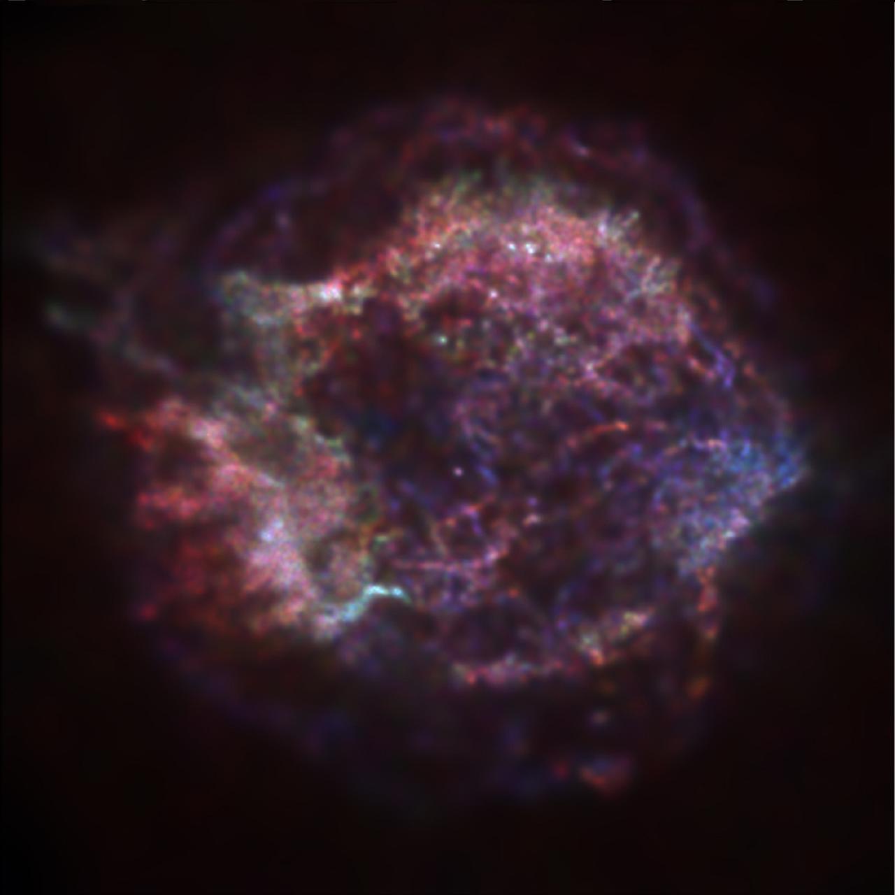 This is an extraordinary first image from the Chandra X-Ray Observatory (CXO), the supernova remnant Cassiopeia A, tracing the aftermath of a gigantic stellar explosion in such sturning detail that scientists can see evidence of what may be a neutron star or black hole near the center. The red, green, and blue regions in this image of the supernova remnant Cassiopeia A show where the intensity of low, medium, and high energy X-rays, respectively, is greatest. The red material on the left outer edge is enriched in iron, whereas the bright greenish white region on the low left is enriched in silicon and sulfur. In the blue region on the right edge, low and medium energy X-rays have been filtered out by a cloud of dust and gas in the remnant . The image was made with the CXO's Advanced Charged-Coupled Device (CCD) Imaging Spectrometer (ACIS). Photo credit: NASA/CXC/SAO/Rutgers/J.Hughes