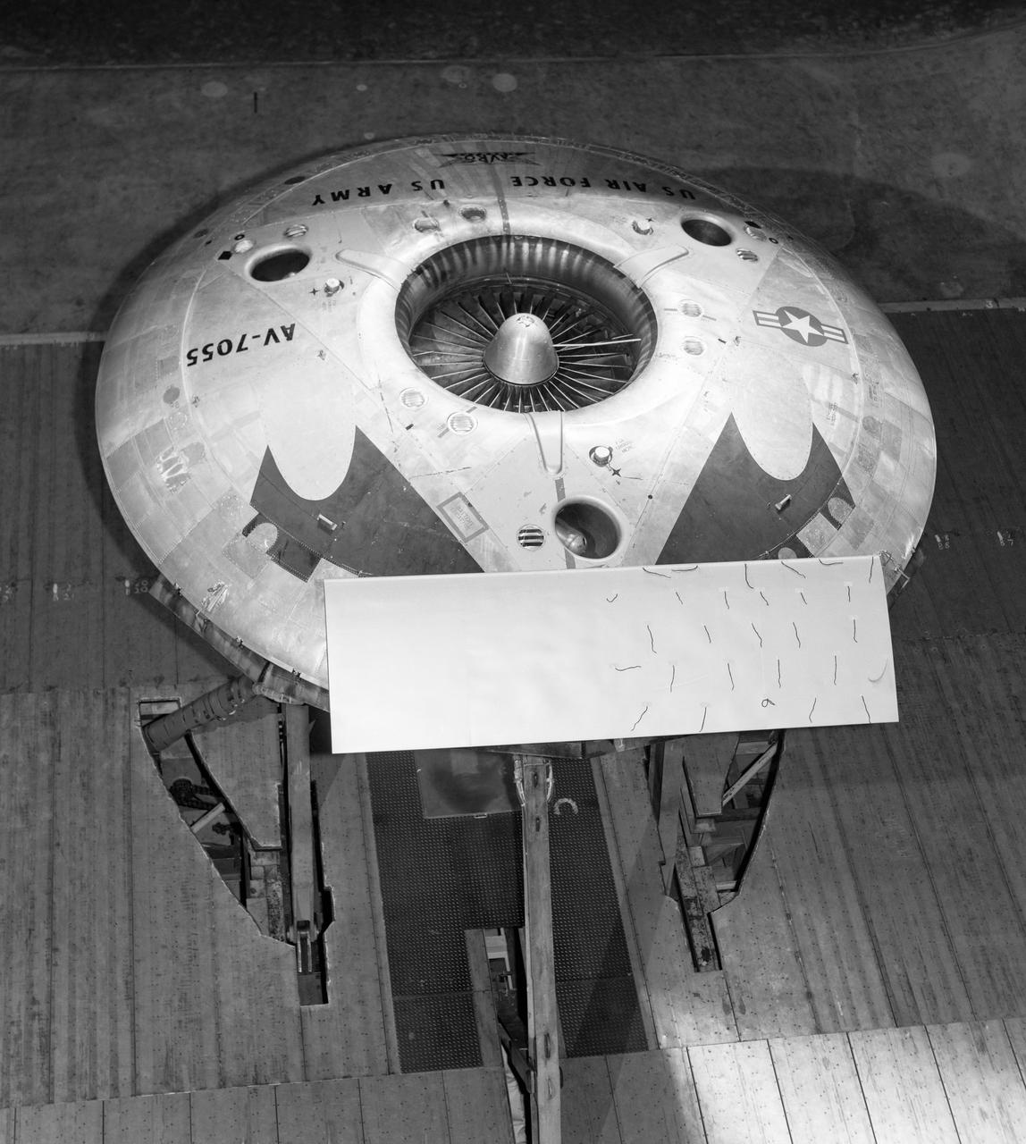 Top rear view of the avrocar with tail.  Tufts  (pieces of yarn) attached to top of horizontal tail.  Avrocar mounted on variable height struts.