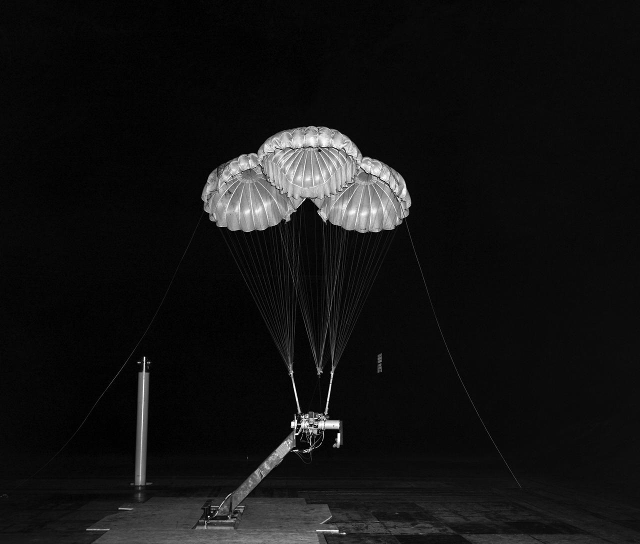 (02/18/1964) Apollo 3 Parachute cluster, flown vertically in 40x80 wind tunnel. Parachutes mounted on a control head with reels to vary the line lengths.