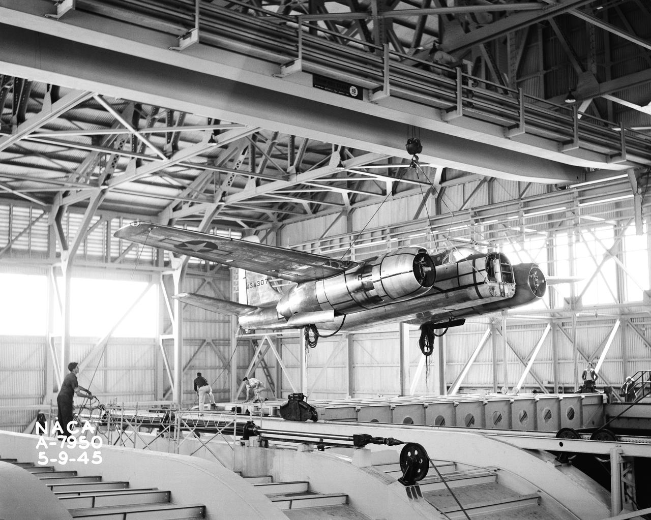 Installation of the Douglas A-26B airplane in the 40x80 foot wind tunnel at NACA's Ames Research Center. Airplane being centered over tunnel opening.