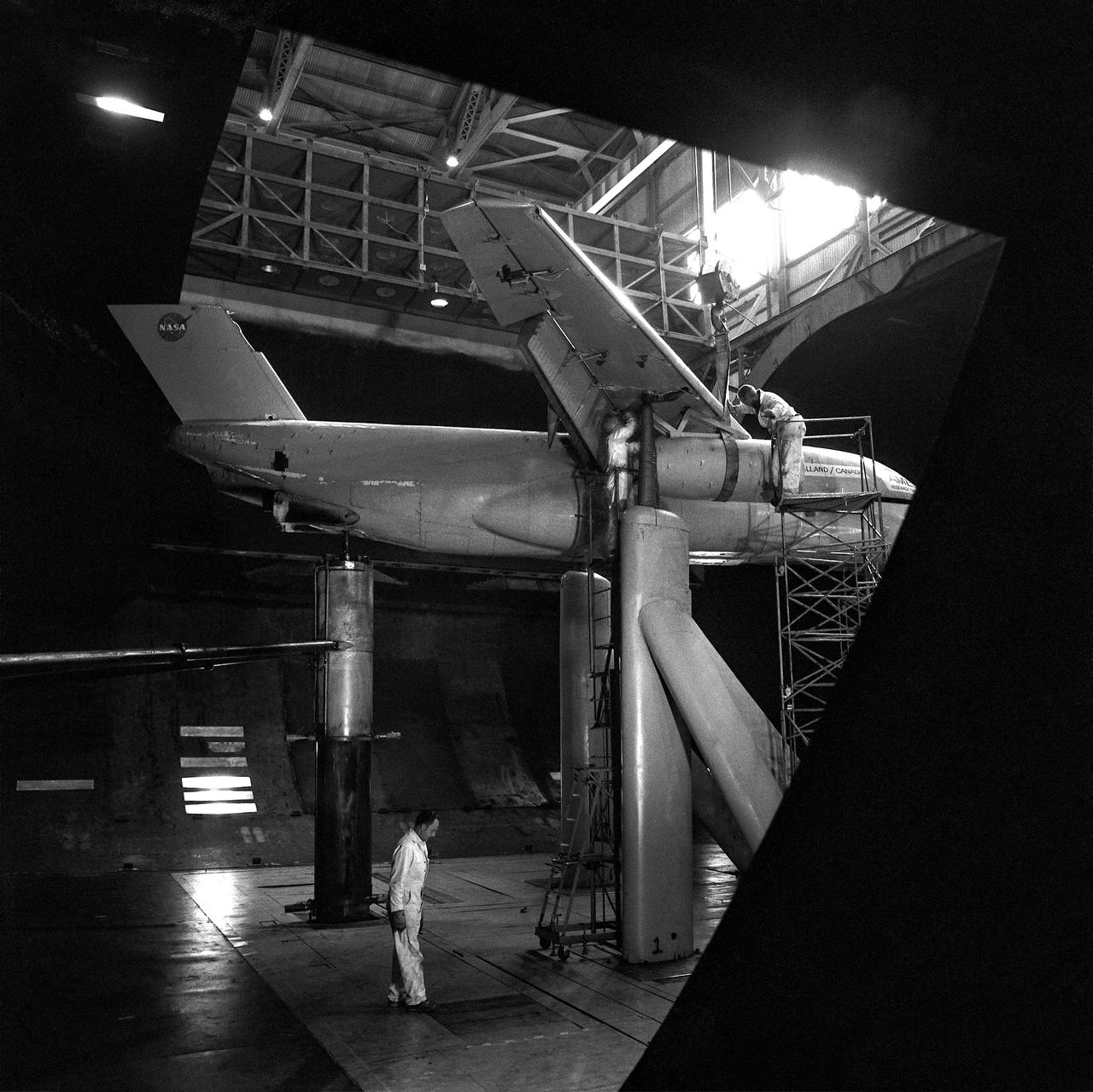 (11/12/1971) 3/4 rear view of swept 75% scale augmentor wing quest model being installed into the test section of the Ames 40x80 foot wind tunnel, overhead doors open.