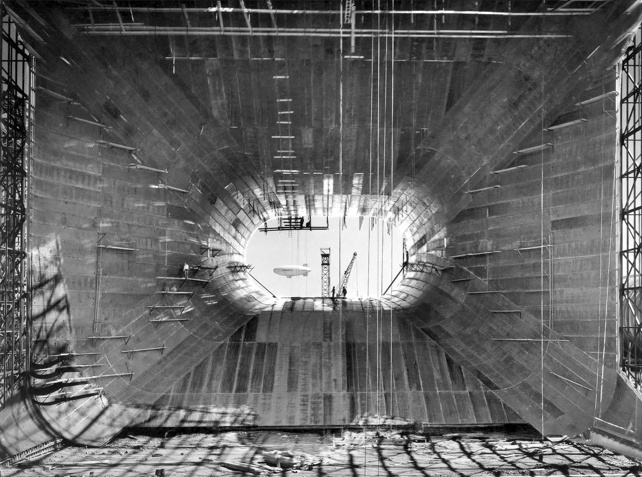 (07/07/1943) Construction view from inside the contraction framing of the 40x80 foot wind tunnel with a blimp flying in the background.