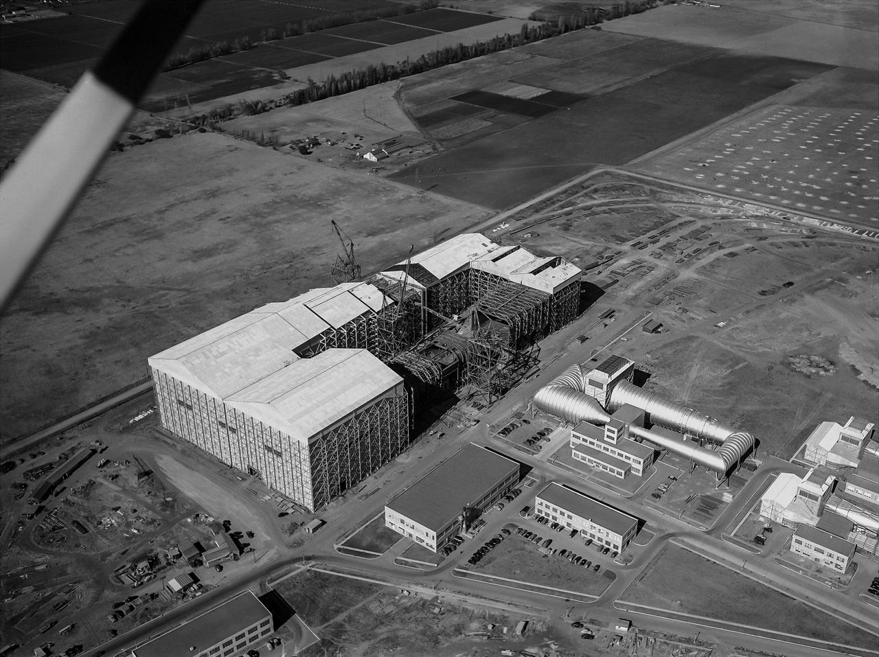 Aerial view looking North West of the nearly completed 40 x 80 foot wind tunnel.  Drive and test section exposed. The facility covered 8 acres, and the air circuit was just over 1/2 mile long (2700 feet).