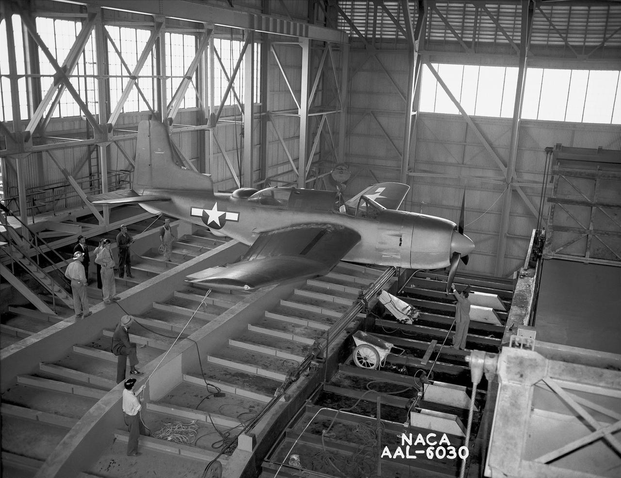 First airplane tested in the ames 40 x 80 foot wind tunnel. Douglas XSB2D-1 (Destroyer)  hanging from overhead crane above the test section.