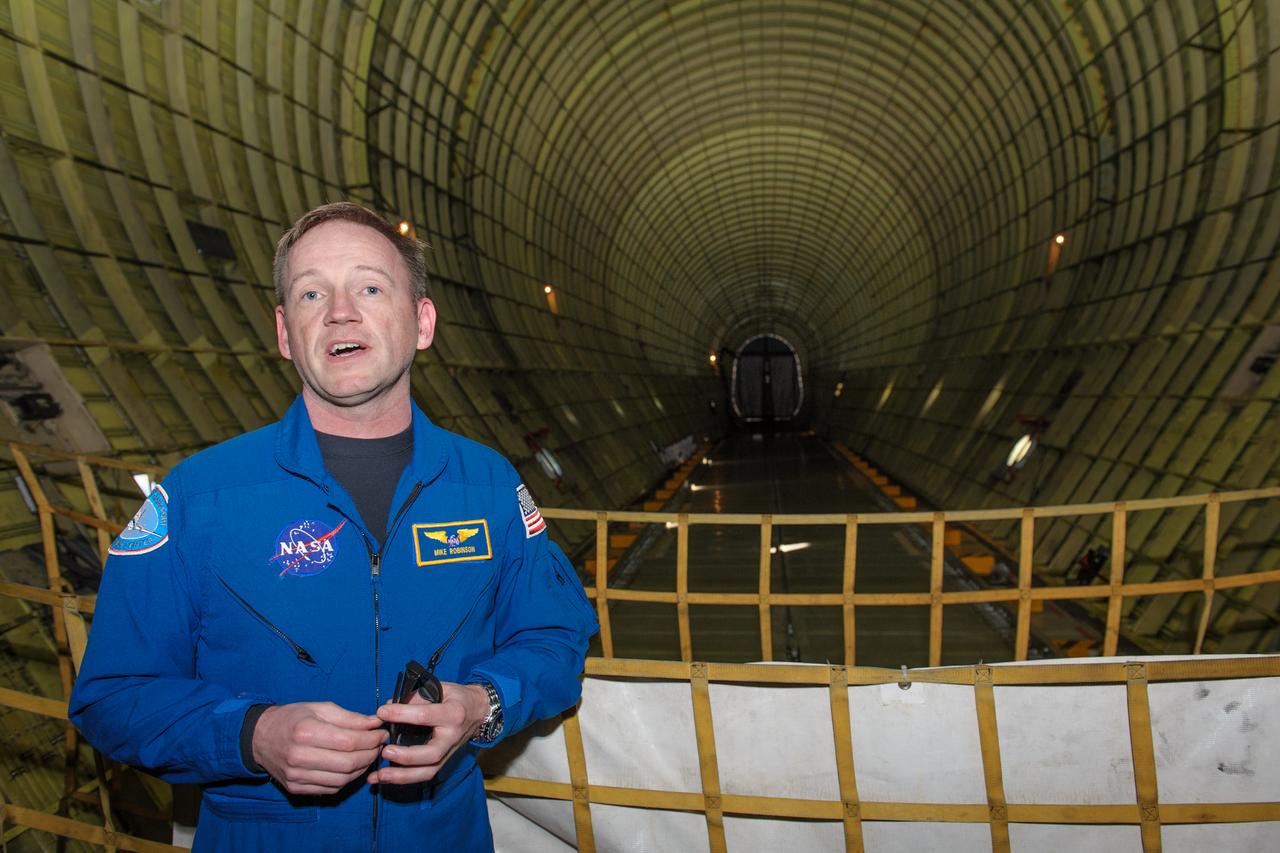 Super Guppy Flight Engineer Michael Robinson inside the Cargo Hold.  The Super Guppy's cargo hold has a useable volume of 39,000 cubic feet and can fly up to 52,000 pounds as far as 564 miles and has a cruising speed of 290 MPH.