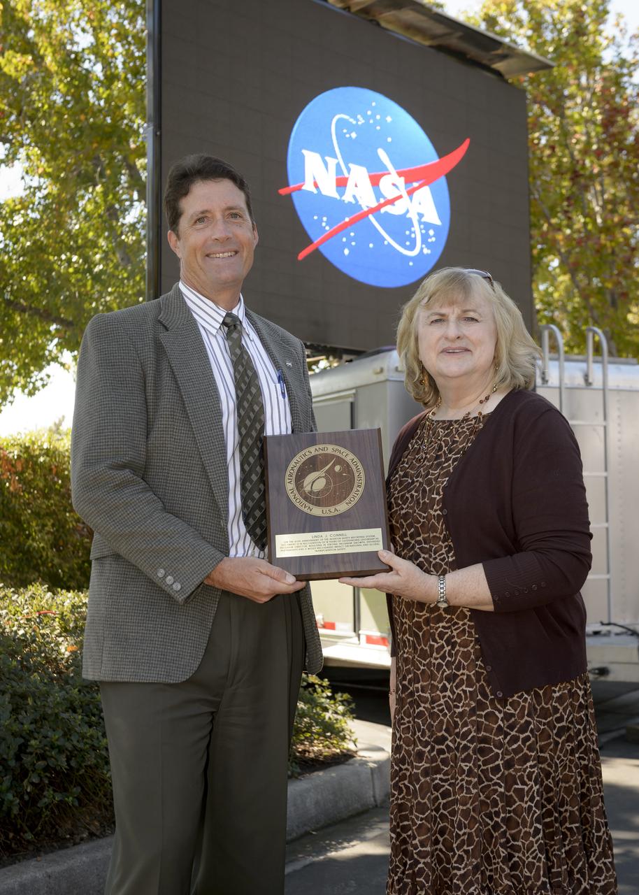Avation Safety Reporting System (ASRS) 40th Anniversary lunch and open house at the Sunnyvale office.  Thomas A Edwards, Deputy Center Director NASA Ames (Left), presents a plaque On the anniversary of the aviation safety reporting system, this award is in recognition of 18 years of outstanding leadership as Program Director, resulting in strong program growth, expanded partnership and a widely recognized impact on National and Global transportation safety. Presented to Linda J. Connell, ASRS Program Director (Right)