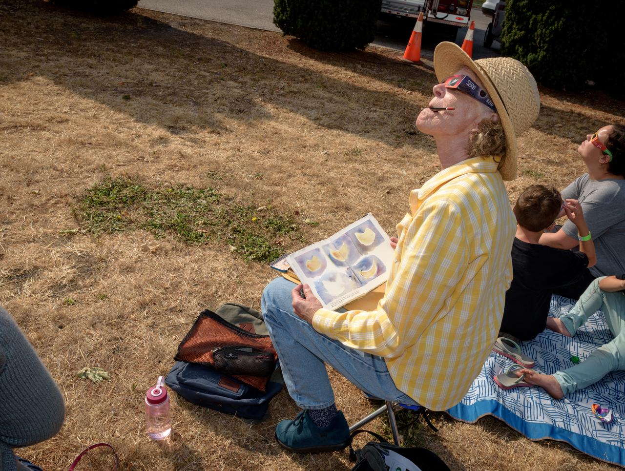 Barbara Grote, sketching the phases of the Moon's transit across the sun on the Patio of Building 3 at NASA Ames during the 2017 Solar Eclipse.