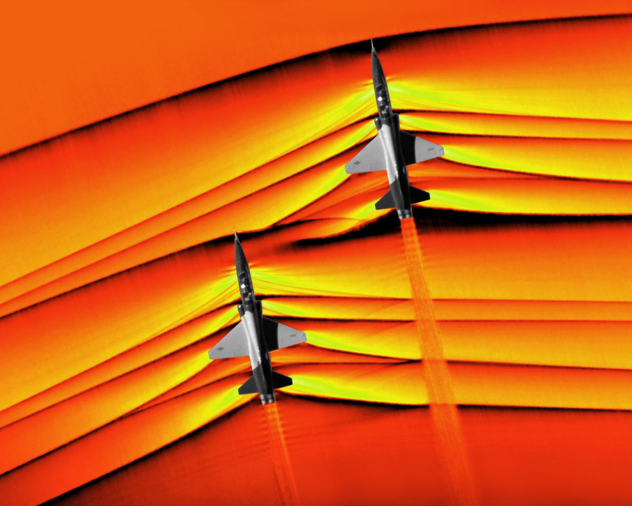 Composite image of Background Oriented Schlieren (BOS) data (contour) with a cut-out images of the T-38’s during a Mach Number 1.02 pass. The interaction of the shockwave of the trailing aircraft with the exhaust plume of the lead aircraft shows a shockwave reflection. Original recording of the pass taken in the Black Mountain Supersonic Corridor at near Edwards AFB in December of 2018. Image acquired by JT Heineck, schlieren data processed by Neal Smith.