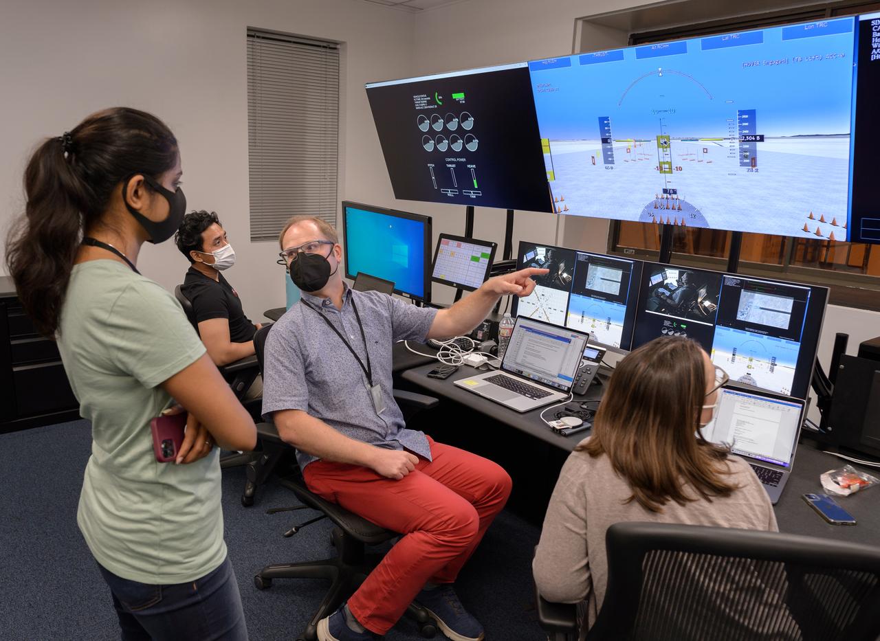 AFCM subproject simulation FAA-2 flight test team members Allen Ruan, left, Thomas Lombaerts, and Kimberlee Shish, right, in the VMS control room, N243, during a simulation.