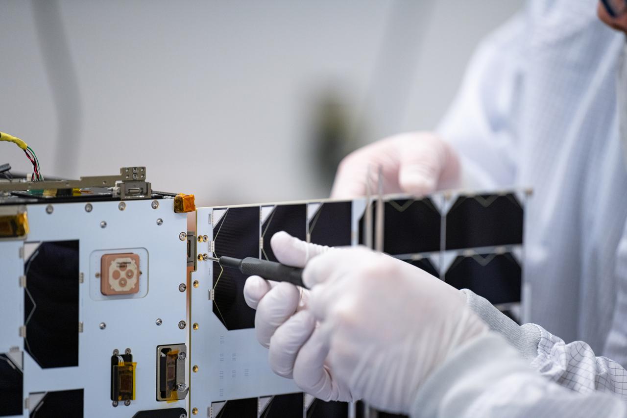 Craig Turczynski, and Mario Perez install the solar panels on the +Y and -Y axis of Advanced Composite Solar Sail System (ACS3) spacecraft in the Ames Integration Facility in N213 room 104.