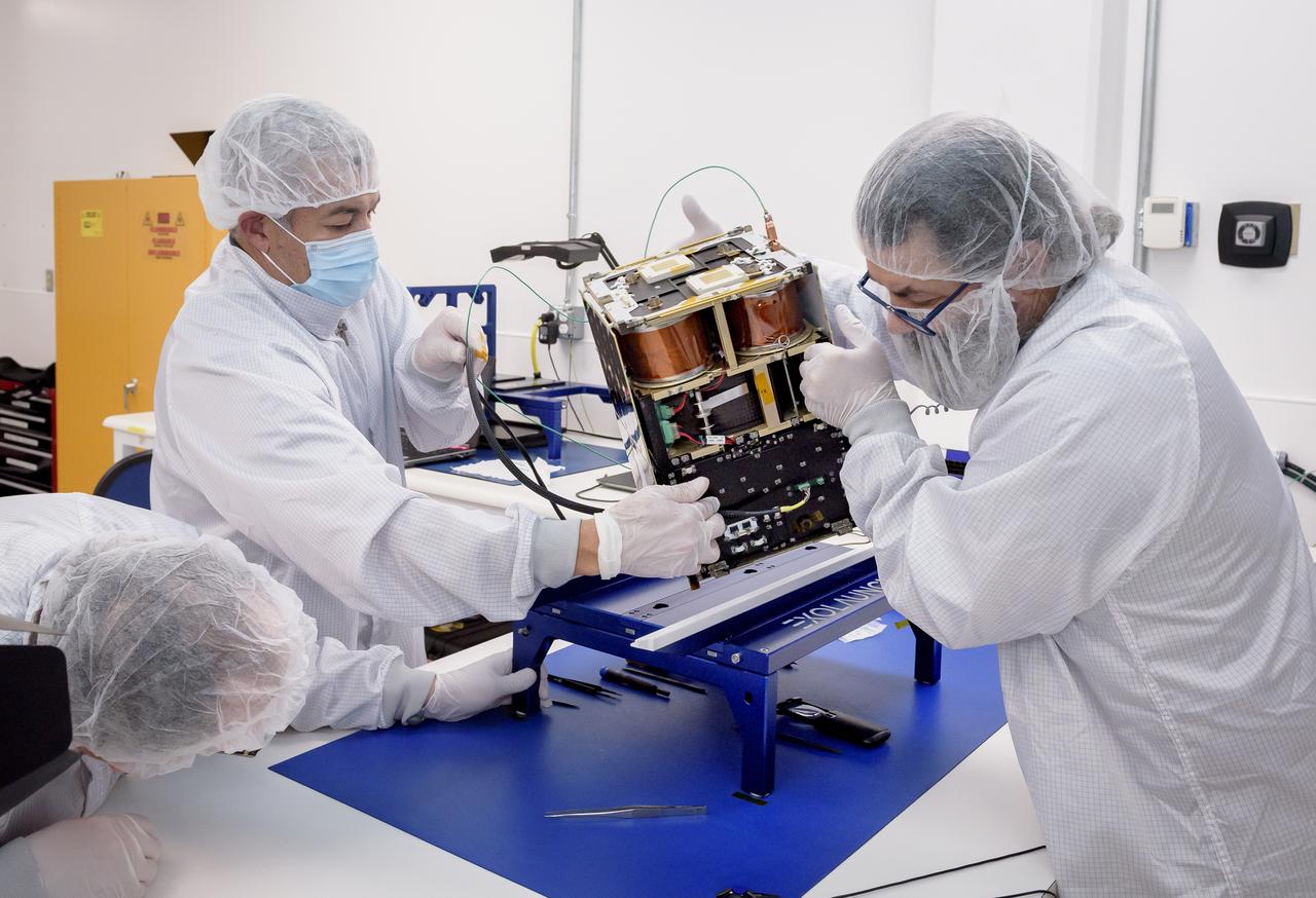 Left to right: Keats Wilkie, Mario Perez, and Craig Turczynski rotate the Advanced Composite Solar Sail System (ACS3) spacecraft on the workbench of the Ames Integration Facility located in N213 room 104.