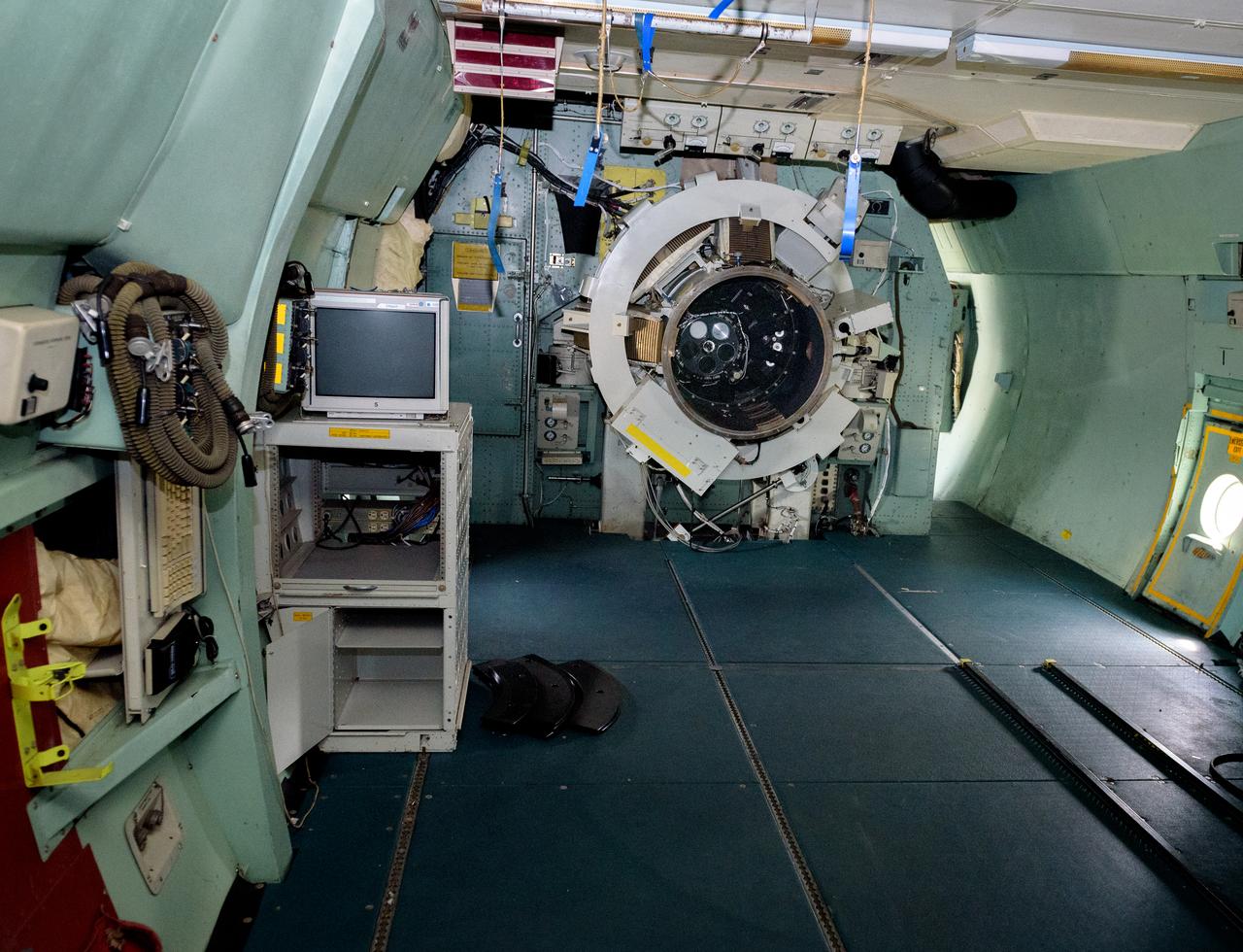 The science instrument mount/telescope flange leading to the telescope cavity.  The port work area is where science instruments were connected to the telescope. Astronomers and the science team sat immediately to the left in the port work area on the modified C-141 Kuiper Airborne Observatory, (KAO) (NASA-714), (seats have been removed).