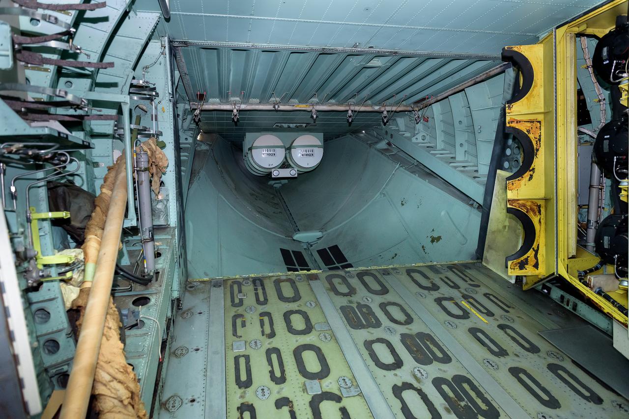 Two nitrogen, LN2, tanks mounted in the aft section of the modified C-141 Kuiper Airborne Observatory, (KAO) (NASA-714), used to cool and purge moisture from the telescope cavity.  The aft pressure door, hinged at top, was closed during flight; the clamshell cargo doors in the aft fuselage could also lower the aft ramp to allow supplies to be driven aboard.