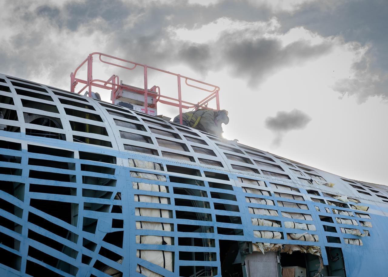 Removing the skin from the airframe of the modified C-141 Kuiper Airborne Observatory, (KAO) (NASA-714), on the N211 apron at Moffett Field, California.