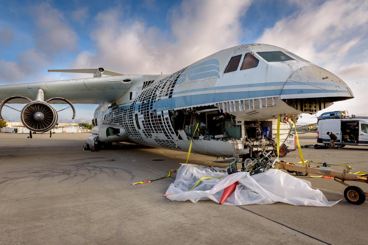 Yellow straps are threaded through the airframe of the modified C-141 Kuiper Airborne Observatory, (KAO) (NASA-714), before removing the cockpit on the N211 apron at Moffett Field, California.