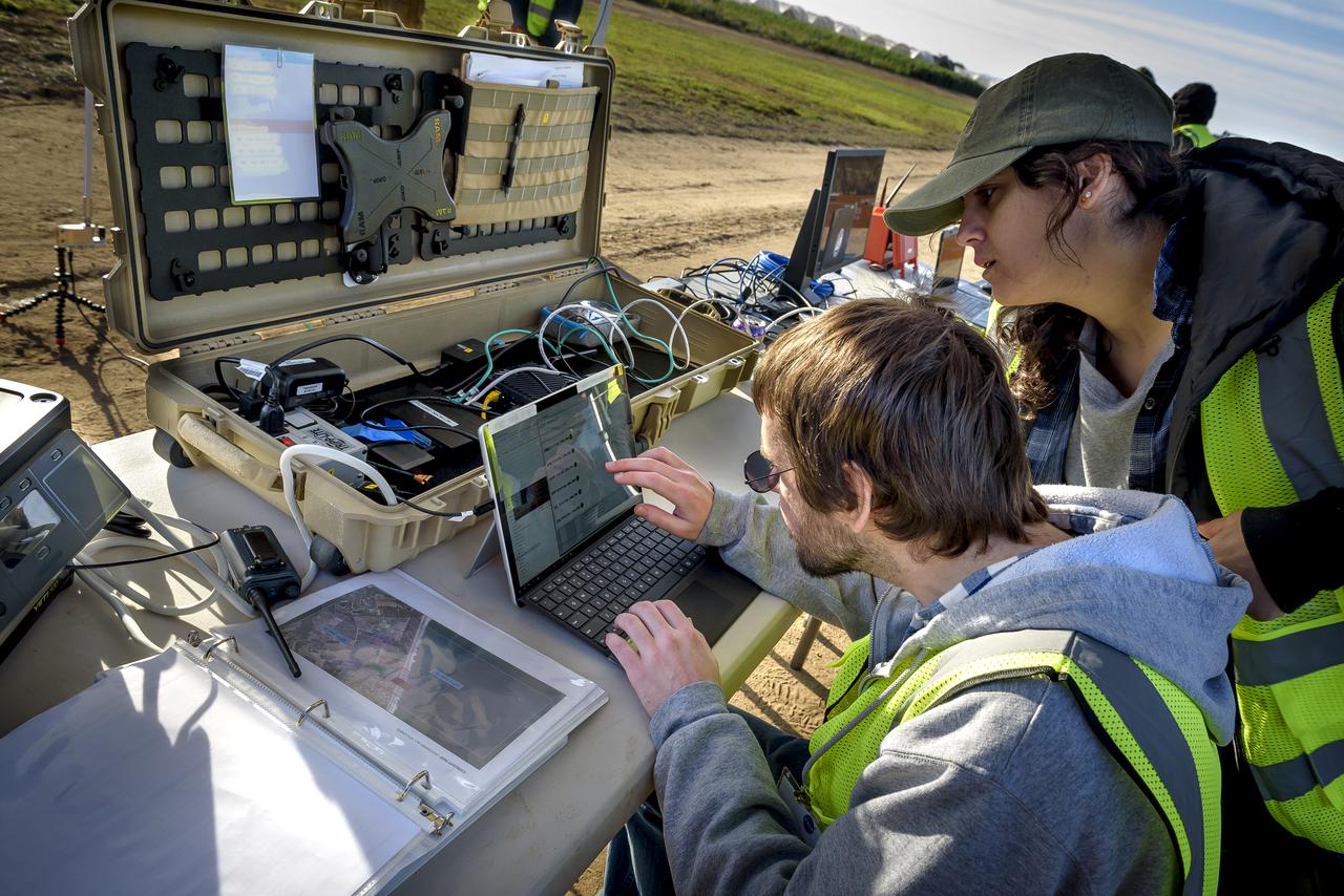 Joshua Kaurich, front, and Yasmin Arbab, works with the Advanced Capabilities for Emergency Response Operations (ACERO) Portable Airspace Management System (PAMS) case at the Monterey Bay Academy Airport near Watsonville, California.