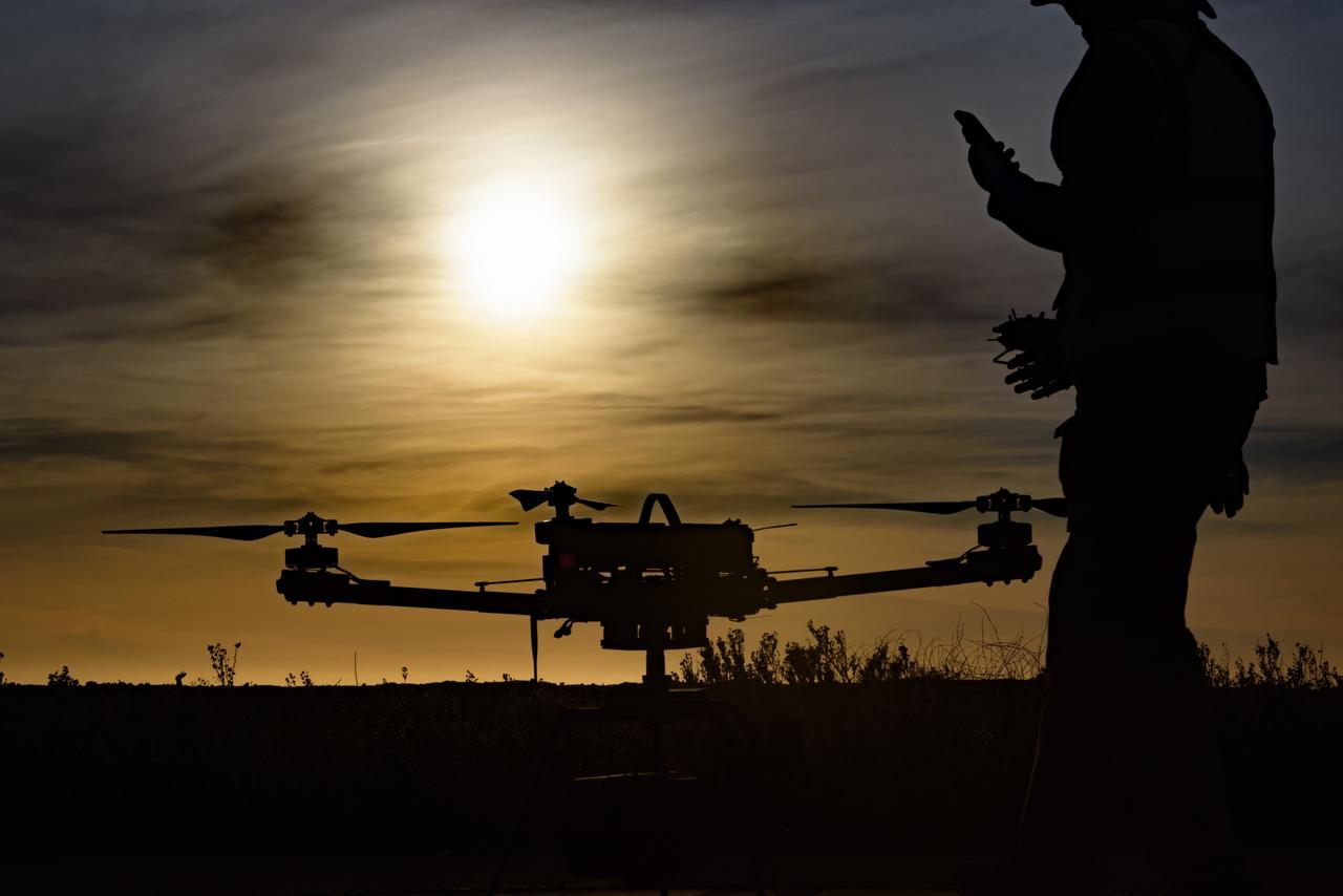 Silhouette view of Jonas Jonsson with the Alta-X Unmanned Aerial Vehicle (UAV) on the landing pad as the sun sets at the Monterey Bay Academy Airport near Watsonville, California.