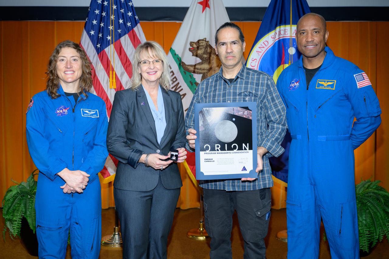 Artemis Orion program manager’s commendation award presented to Enrique Carballo, center, by Orion Deputy Program Manager Debbie Korth, left, NASA astronauts Victor J. Glover, right, and Christina Koch, left, in the N201 auditorium.