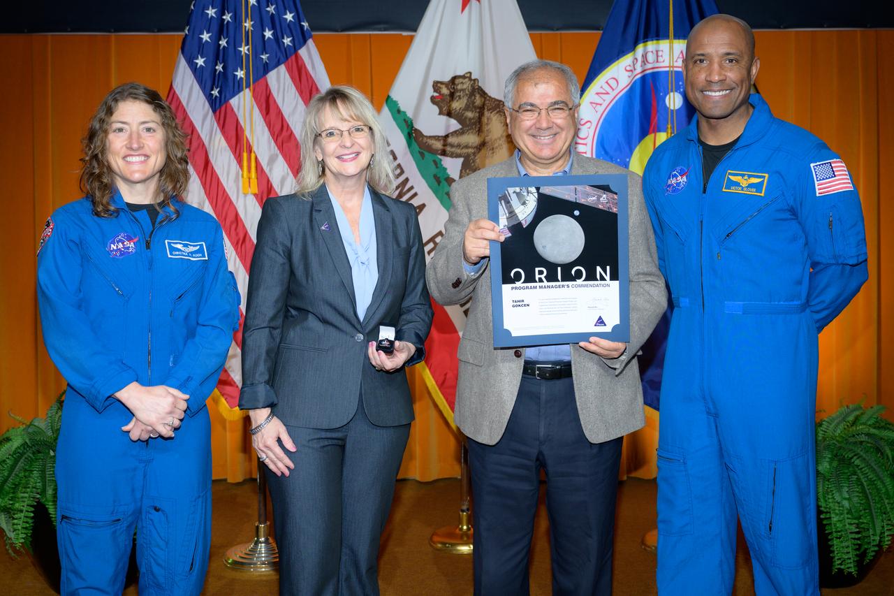 Artemis Orion program manager’s commendation award presented to Tahir Gokcen, center, by Orion Deputy Program Manager Debbie Korth, left, NASA astronauts Victor J. Glover, right, and Christina Koch, left, in the N201 auditorium.