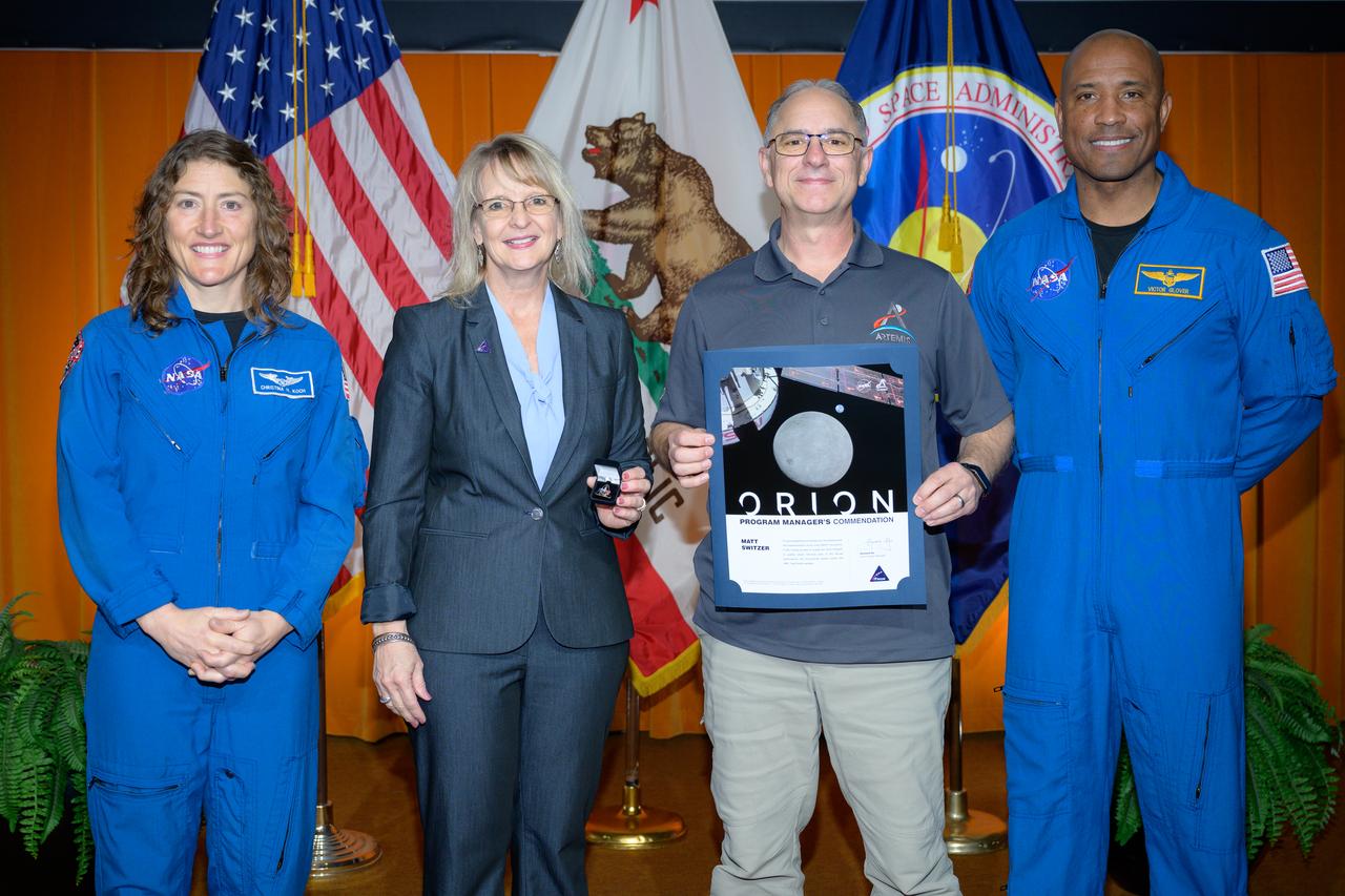 Artemis Orion program manager’s commendation award presented to Matt Switzer, center, by Orion Deputy Program Manager Debbie Korth, left, NASA astronauts Victor J. Glover, right, and Christina Koch, left, in the N201 auditorium.