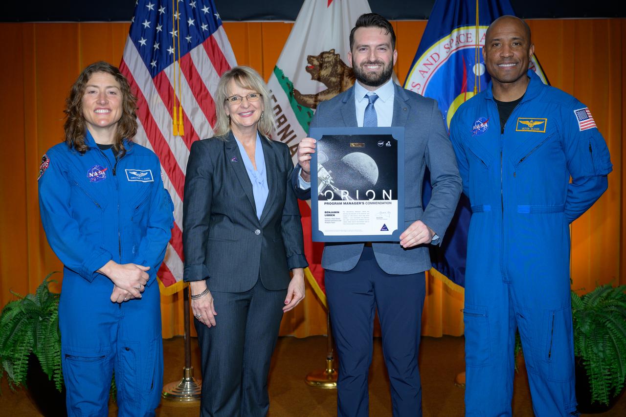 Artemis Orion program manager’s commendation team award presented to the Artemis I Heat Shield Sample Extraction and Analysis team accepted by Benjamin Libben, center, by Orion Deputy Program Manager Debbie Korth, left, NASA astronauts Victor J. Glover, right, and Christina Koch, left, in the N201 auditorium.