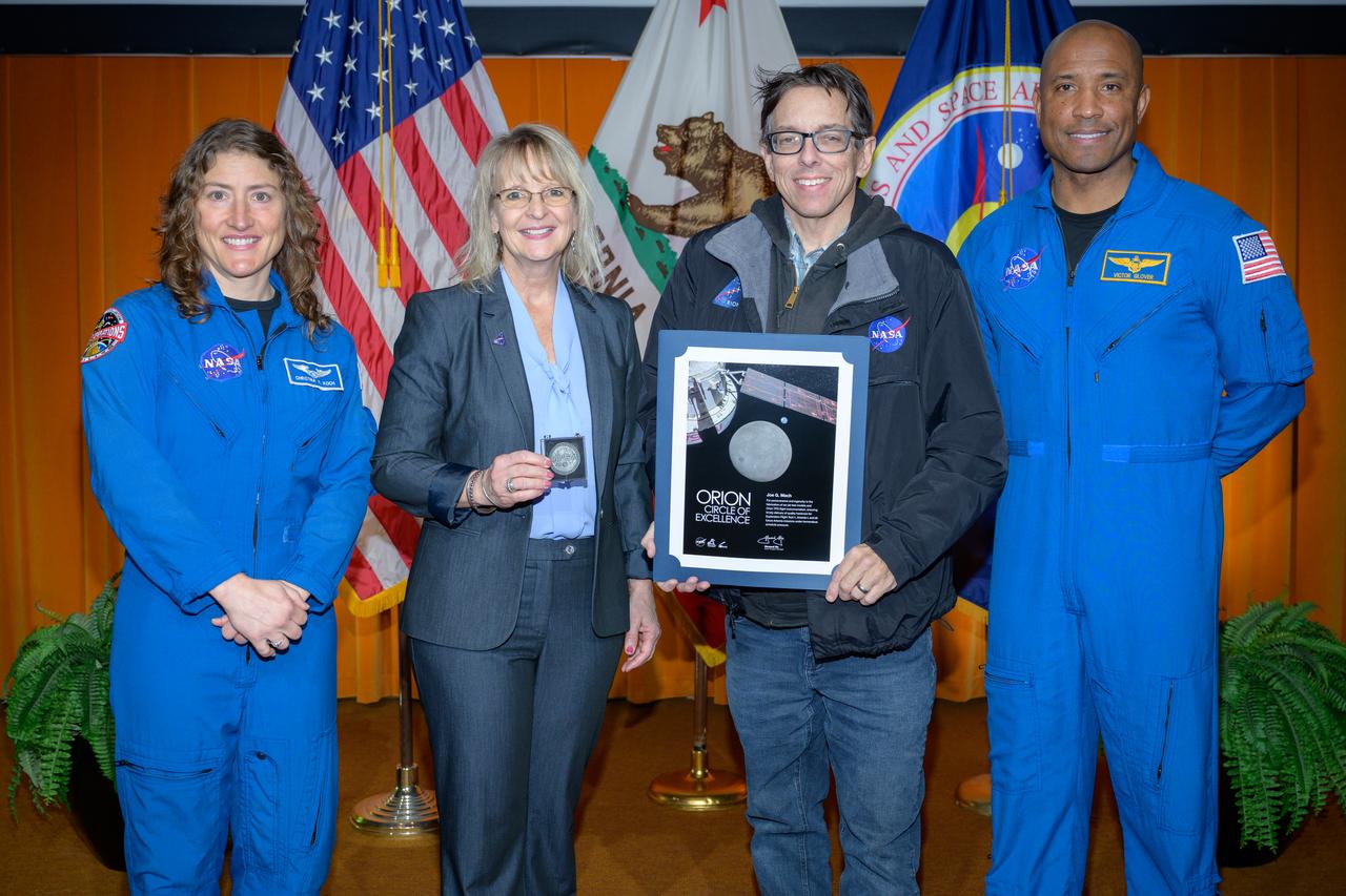 Artemis Orion Circle of Excellence Award presented to Joe G. Mach, center, by Orion Deputy Program Manager Debbie Korth, left, NASA astronauts Victor J. Glover, right, and Christina Koch, left, in the N201 auditorium.