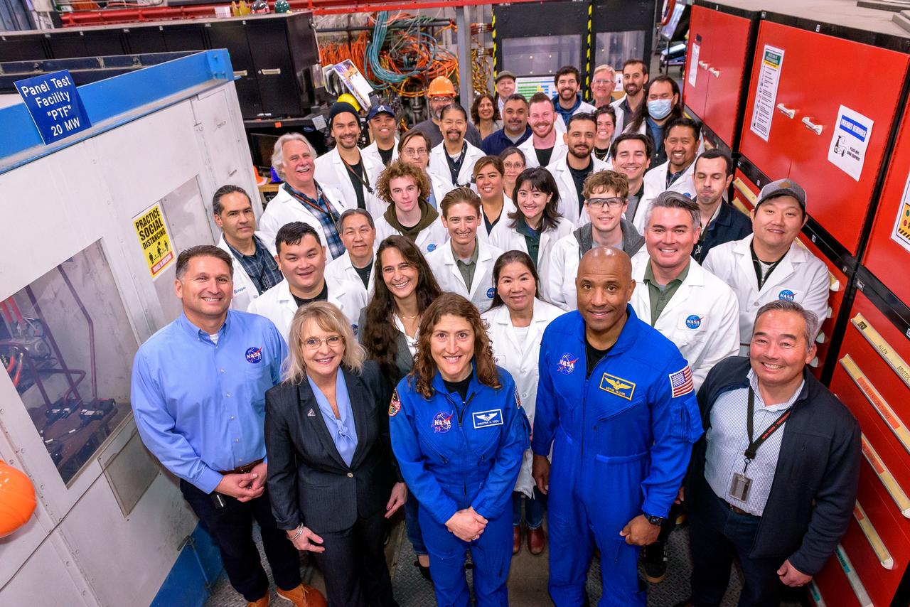 Group photo of the Orion astronauts with the staff of the Ames Arc Jet Complex in N238.  Front row: Luis Saucedo, left, Debbie Korth, Christina Koch, Victor J. Glover, and George Raiche, right.