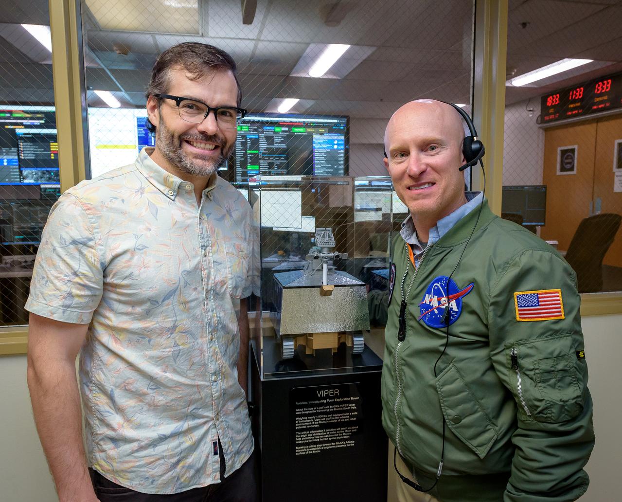 Zachary Burkland left and Justin Pane outside the Volatiles Investigating Polar Exploration Rover (VIPER) vehicle operational readiness test in the Multi-Mission Operations Center (MMOC), N240A.