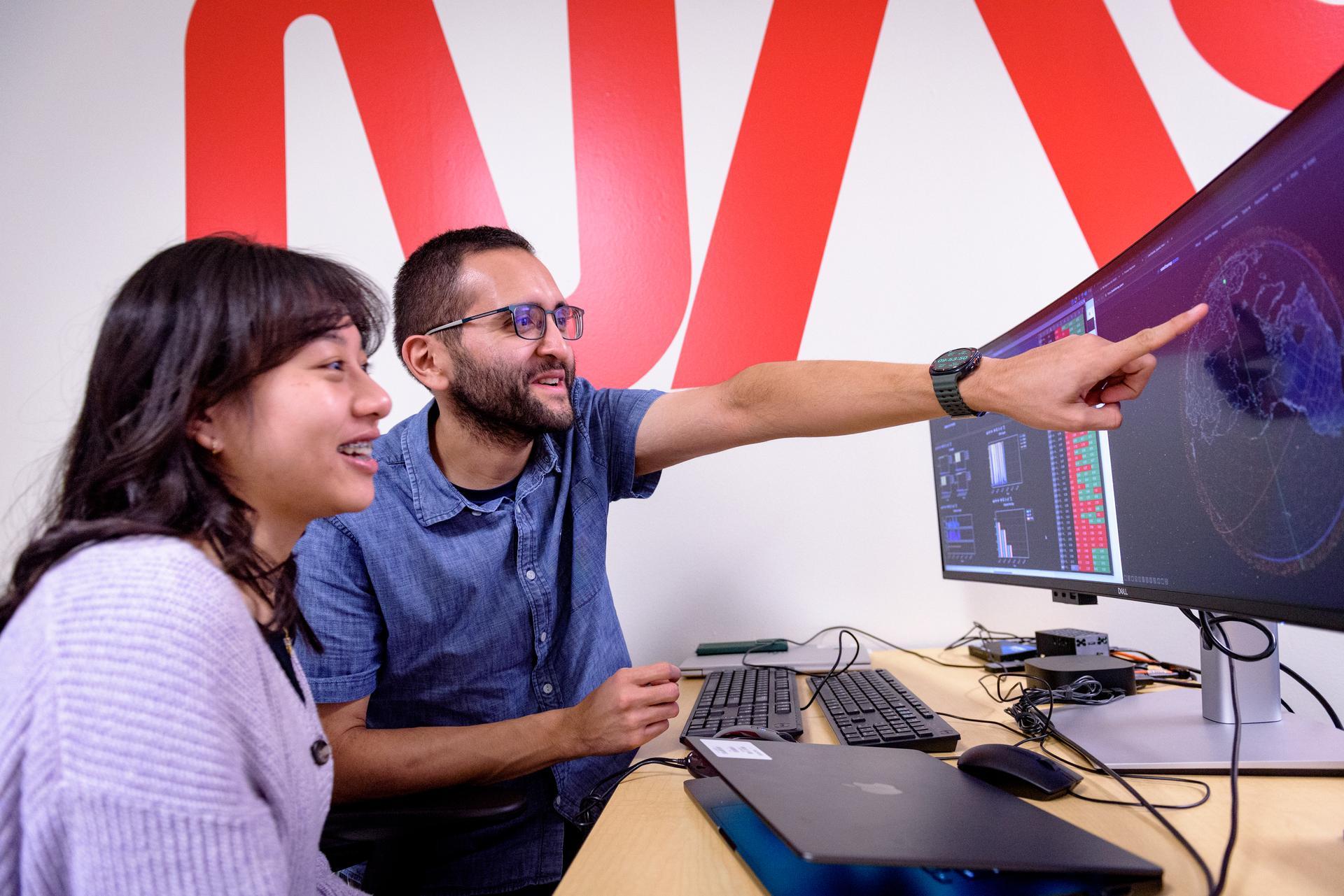 TechEdSat-11 operators Daphne Dao, left, and Alejandro Salas, in the Ames Multi-Mission Operations Center (MMOC), N240 Annex, Eros control room 162. The team monitors the spacecraft's status during the Exo-Brake “parachute” deployment.   The ExoBrake is a drag device that increases the total surface area of the spacecraft to assist with a quicker deorbit. This maneuver is deployed at the end of mission to satisfy NASA's deorbit requirement and prevent space debris. TechEdSat has spent the last several months coordinating with NASA’s Conjunction Assessment Risk Analysis (CARA) team to ensure the spacecraft can safely deploy the ExoBrake without colliding into any other objects.