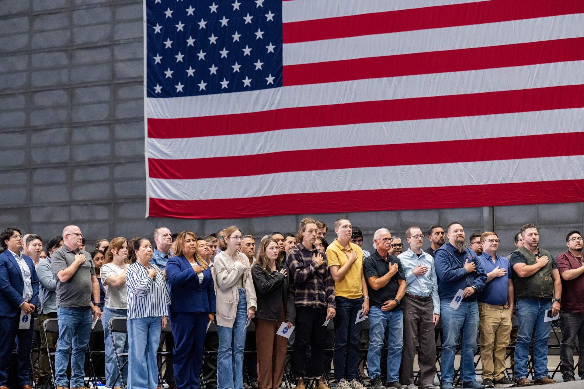 Attendees stand for the National Anthem during the NASA Civil Servant Swearing-in Ceremony in the National Full-Scale Aerodynamics Complex (NFAC) 80-by-120-foot test section, N221.