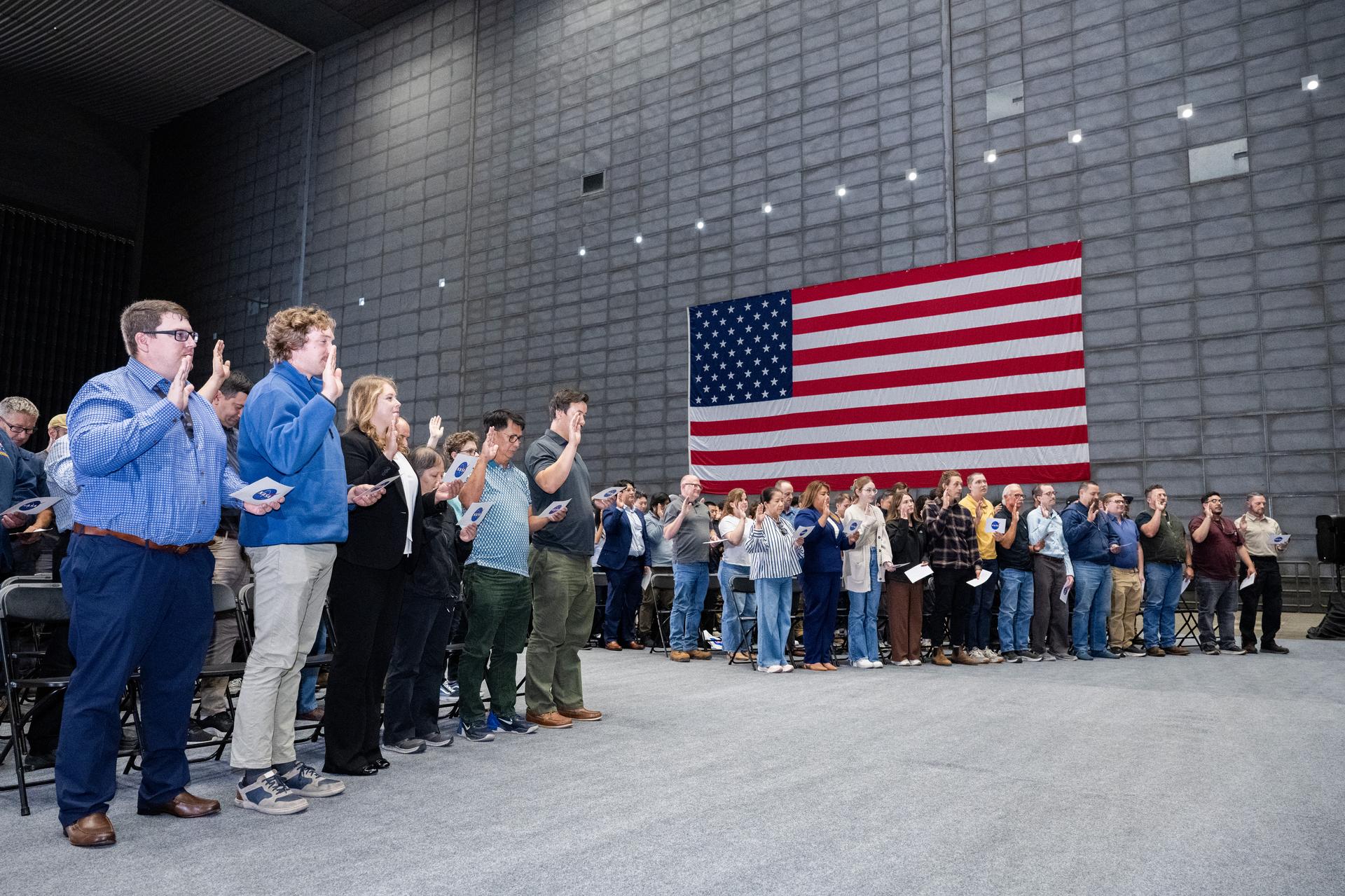 Participants stand while Associate Administrator Amit Kshatriya administers the Oath of Office during the NASA Civil Servant Swearing-in Ceremony in the National Full-Scale Aerodynamics Complex (NFAC) 80-by-120-foot test section, N221.