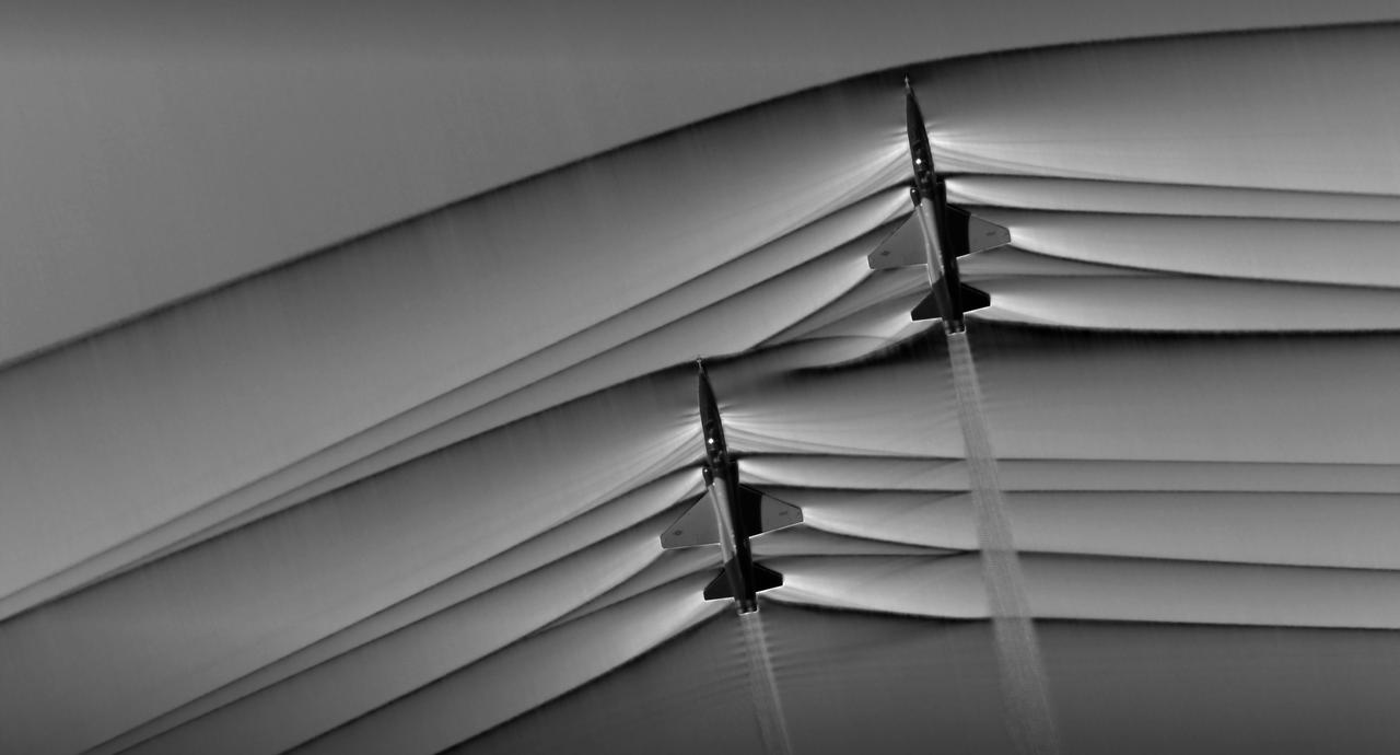 Composite image of Background Oriented Schlieren (BOS) data (contour) with a cut-out images of the T-38’s during a Mach Number 1.01 pass. This data is the first time shockwave interactions between two full scale aircraft traveling faster than the speed of sound have been imaged and shown with schlieren visualization. Original recording of the pass taken in the Black Mountain Supersonic Corridor at near Edwards AFB in December of 2018. Image acquired by JT Heineck, schlieren data processed by Neal Smith.