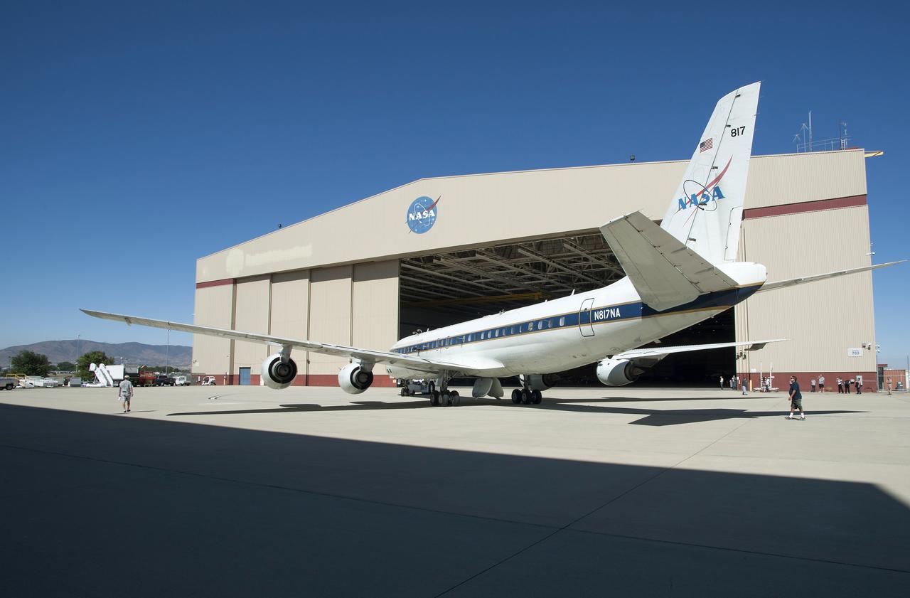 Media observe as ground crews tow NASA’s DC-8 airborne laboratory into its Palmdale, California hangar.