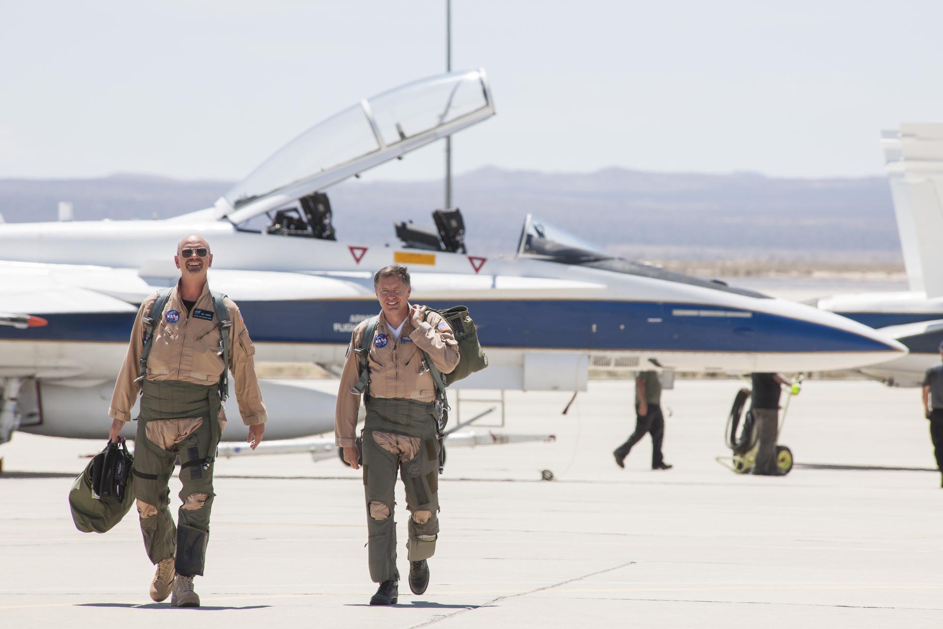 NASA pilot Nils Larson, and flight test engineer and pilot Wayne Ringelberg, head for a mission debrief after flying a NASA F/A-18 at Mach 1.38 to create sonic booms.