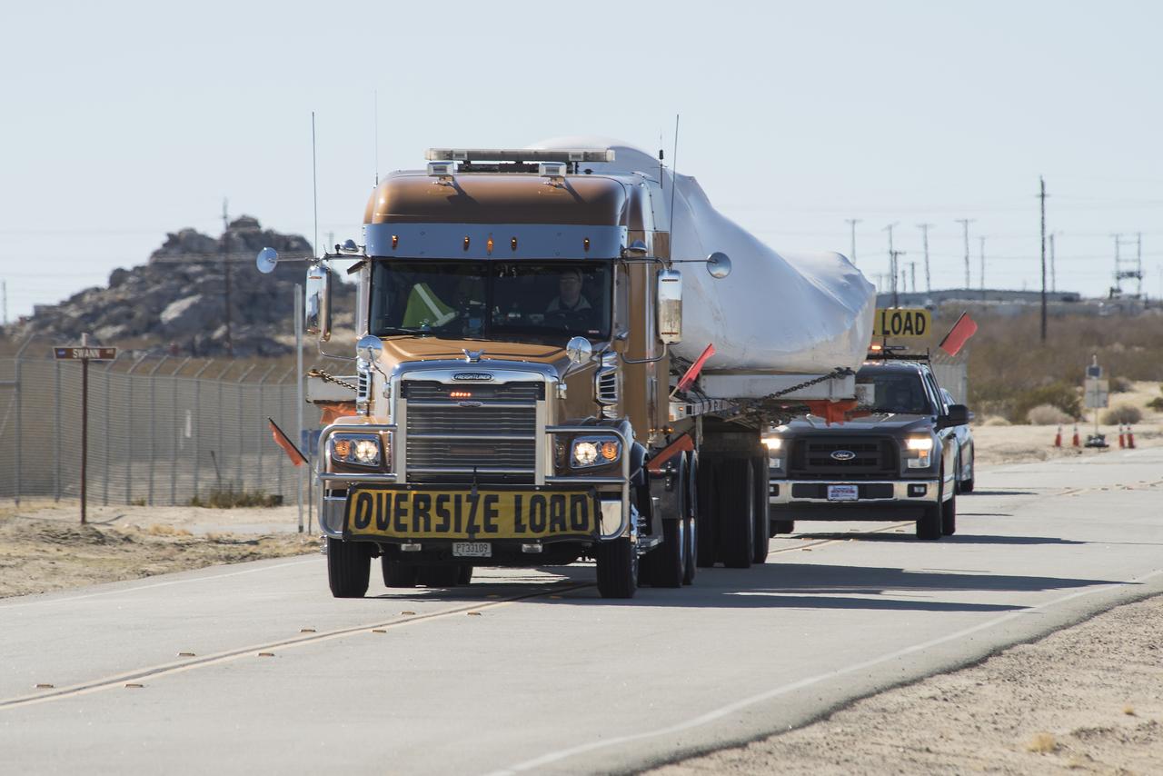 Sierra Nevada Corporation’s Dream Chaser spacecraft arrives by truck at NASA’s Armstrong Flight Research Center in California, located on Edwards Air Force Base. The spacecraft will undergo several months of testing in preparation for its approach and landing flight on the base’s 22L runway. The test series is part of a developmental space act agreement SNC has with NASA’s Commercial Crew Program and will help SNC validate aerodynamic properties, flight software and control system performance. The Dream Chaser is also being prepared to deliver cargo to the International Space Station under NASA’s Commercial Resupply Services 2 contract beginning in 2019. The cargo Dream Chaser will fly at least six delivery missions to and from the space station by 2024.