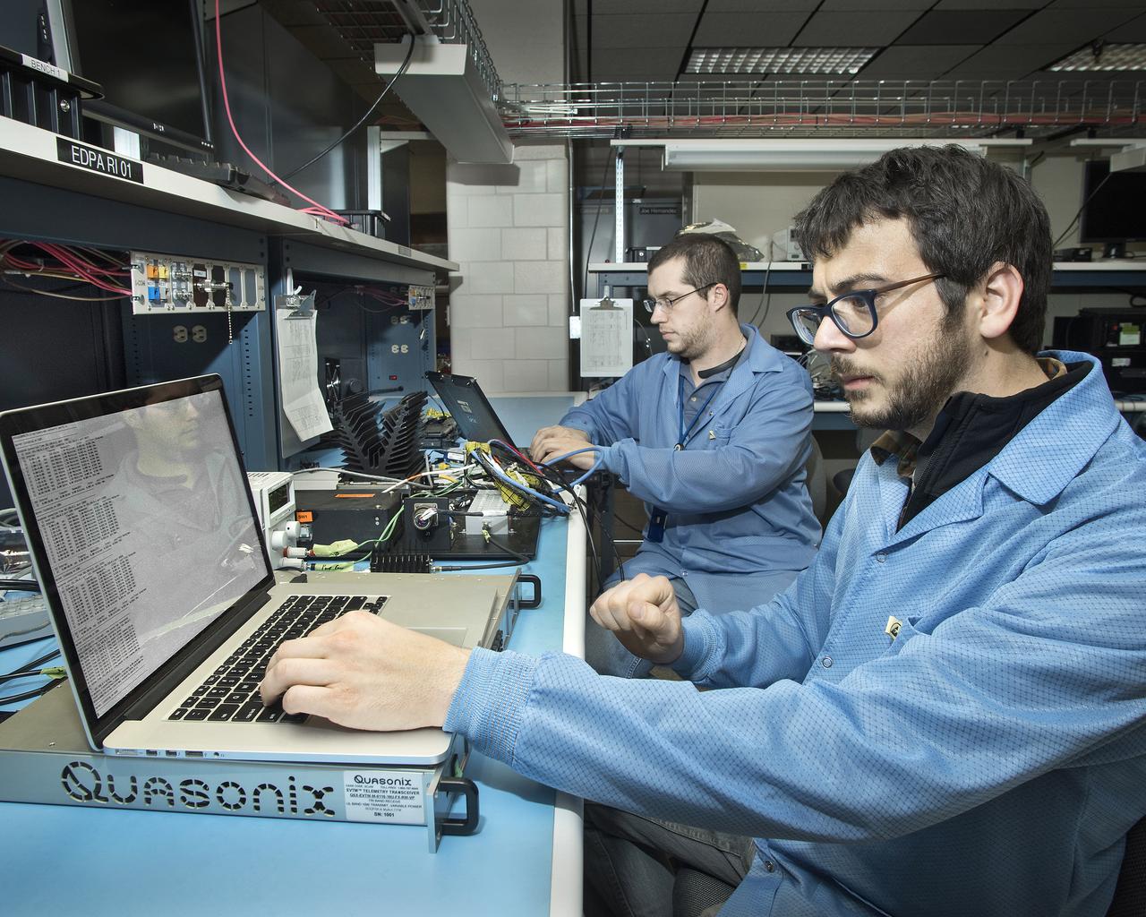 Otto Schnarr, front, and Matthew Waldersen check out the Advanced Data Acquisition and Telemetry System in an Armstrong laboratory.