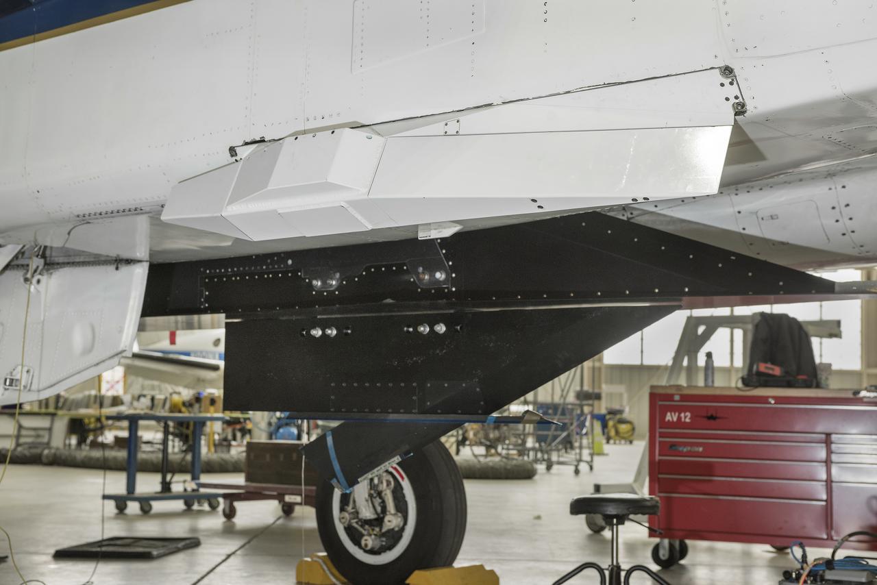 The Swept Wing Laminar Flow test article, integrated to the underside of a NASA F-15, will examine the effectiveness of different configurations of small dots, called distributed roughness elements, to extend smooth, laminar airflow over a wing’s depth, reducing friction drag.