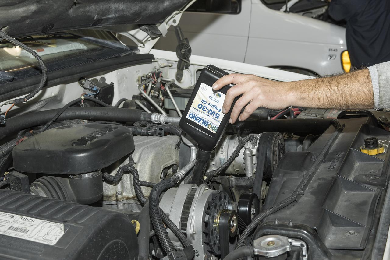 A new bio-based synthetic engine oil is added to one of the vehicles that Armstrong is using to assist in performance testing of the new product.