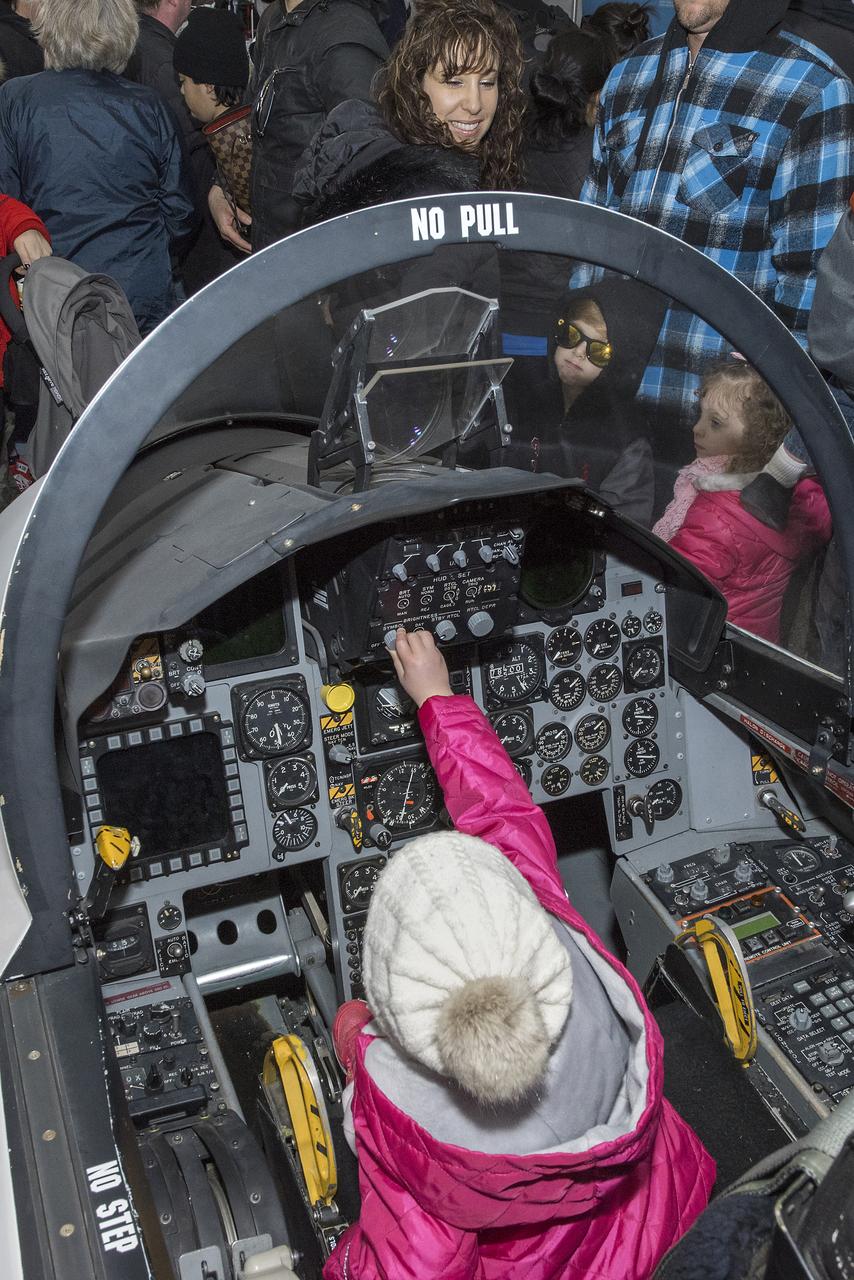 A young woman tries her hand at “piloting” a high-performance jet. The representation of a jet cockpit is a popular display at NASA Armstrong-supported air shows and festivals across the nation.