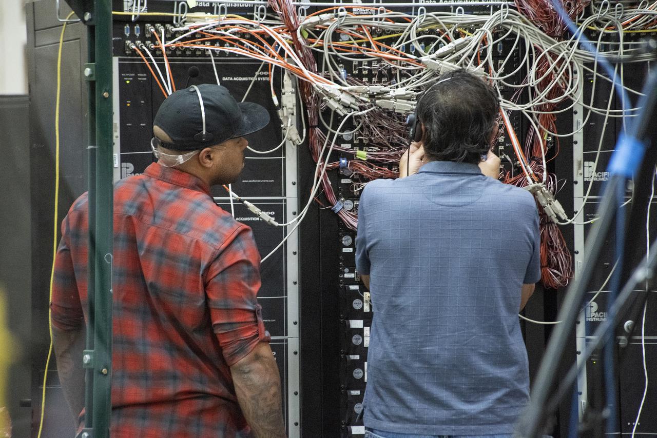 Eric Sinks, left, and Ron Haraguchi work through a challenge with the wiring from the Passive Aeroelastic Tailored wing to the test fixture.