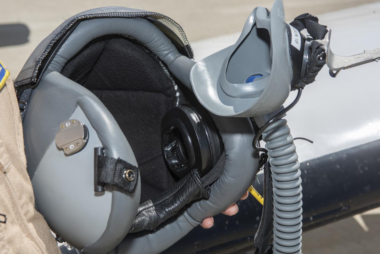 The black circle inside the helmet on the right contains some of the new elements of a noise reduction headphone that is part of an Active Noise Reduction system. It helps pilots hear better and improve communication during flight research missions.