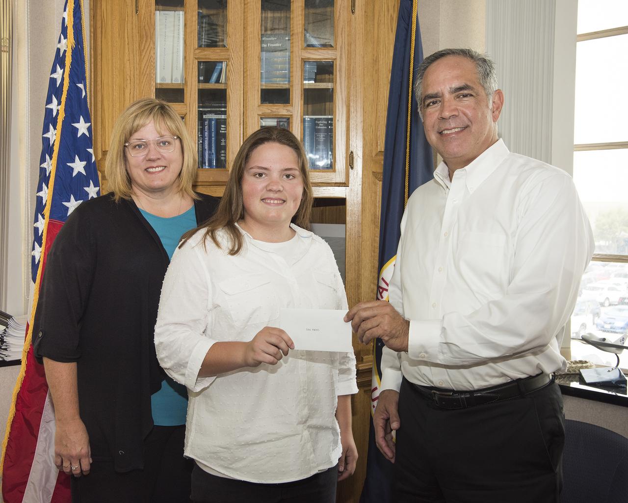 Erin Askins, second from left, accepts the 2018 NASA Armstrong Exchange Harold W. Walker Memorial Scholarship from Center Director David McBride. Next to Erin Askins is her mother Dana Askins.