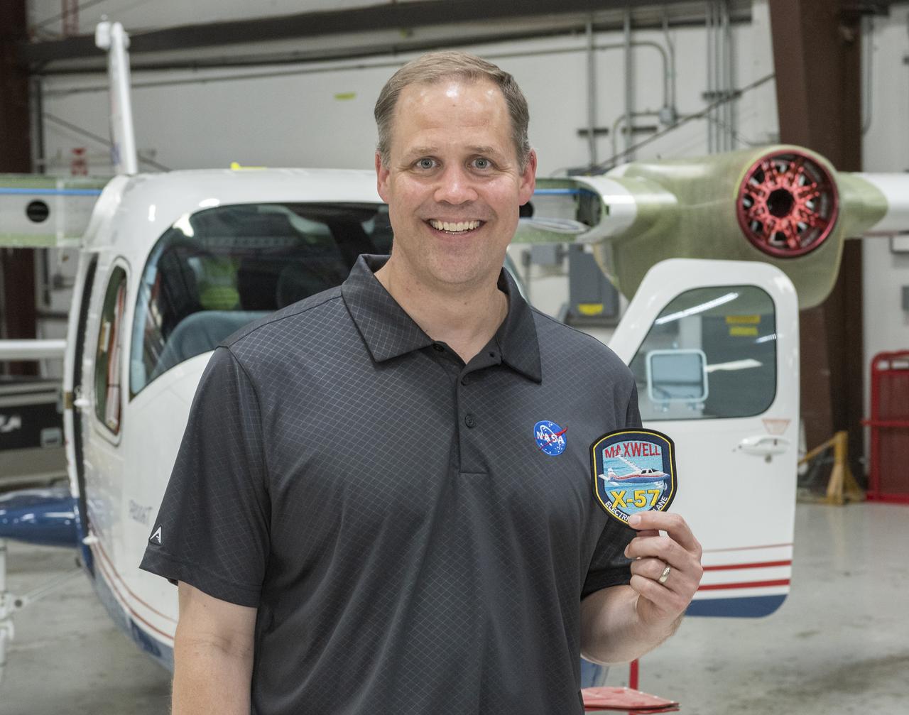Administrator Bridenstine receives X-57 program patch standing in front of the X-57 being modified from combustion Tecnam P2006T aircraft into all-electric aircraft in Scaled Composites hangar at Mojave Air & Space Port in California.